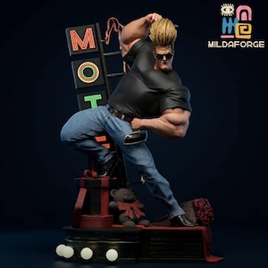 Peut inclure: Figurine d'un homme musclé en chemise noire, jean bleu et lunettes de soleil, prenant une pose. La figurine a les cheveux blonds et est positionnée près d'une enseigne au néon "MOT". Un ours en peluche et un nœud rouge sont à la base. Le logo MILDAFORGE est en haut à droite.