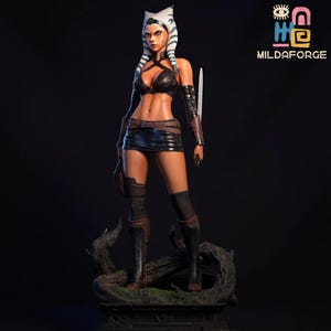 Puede incluir: Figura detallada de un personaje femenino con colas de cabeza blancas y azules, que lleva un atuendo negro, que incluye un top, una falda y botas. La figura sostiene una hoja blanca y se encuentra sobre una base de madera. El logotipo "MILDAFORGE" es visible.