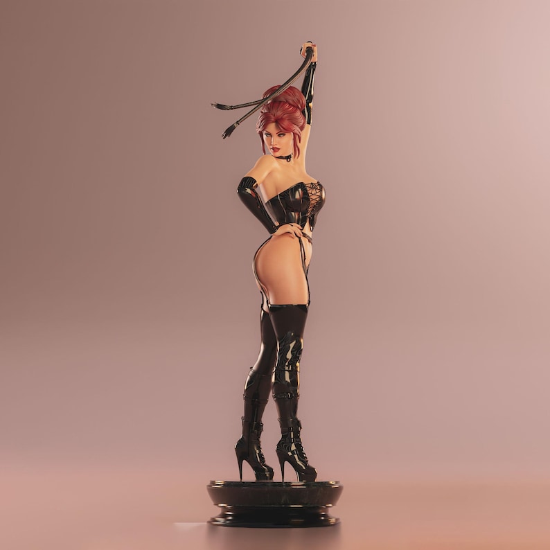 May include: A figurine of a woman in a black corset, thigh-high boots, and gloves, holding a whip. The figure has red hair and is standing on a black base. The background is a gradient of pink and brown.