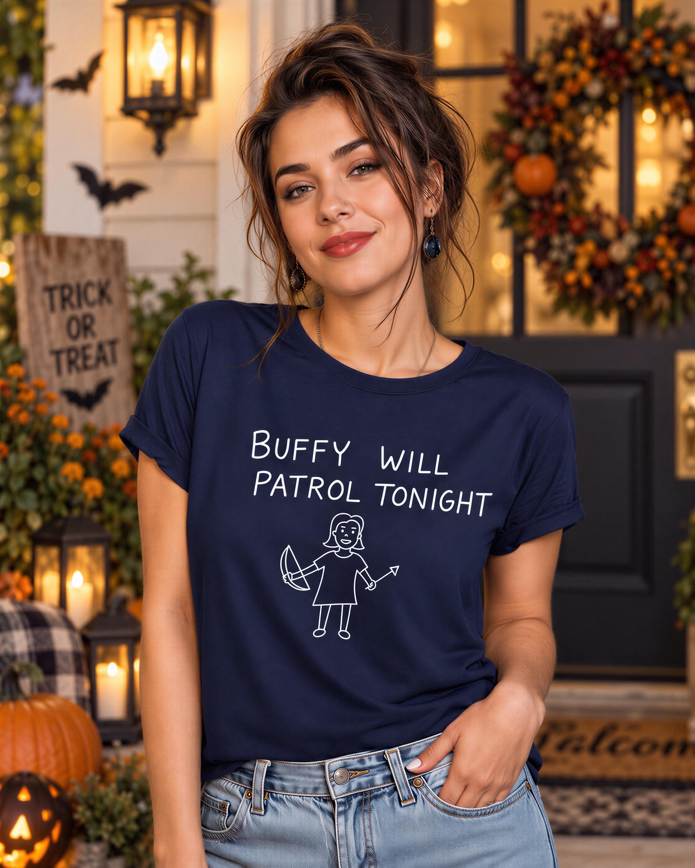 A woman wearing a navy blue t-shirt with the text "Buffy Will Patrol Tonight" is standing in front of a Halloween-themed backdrop.