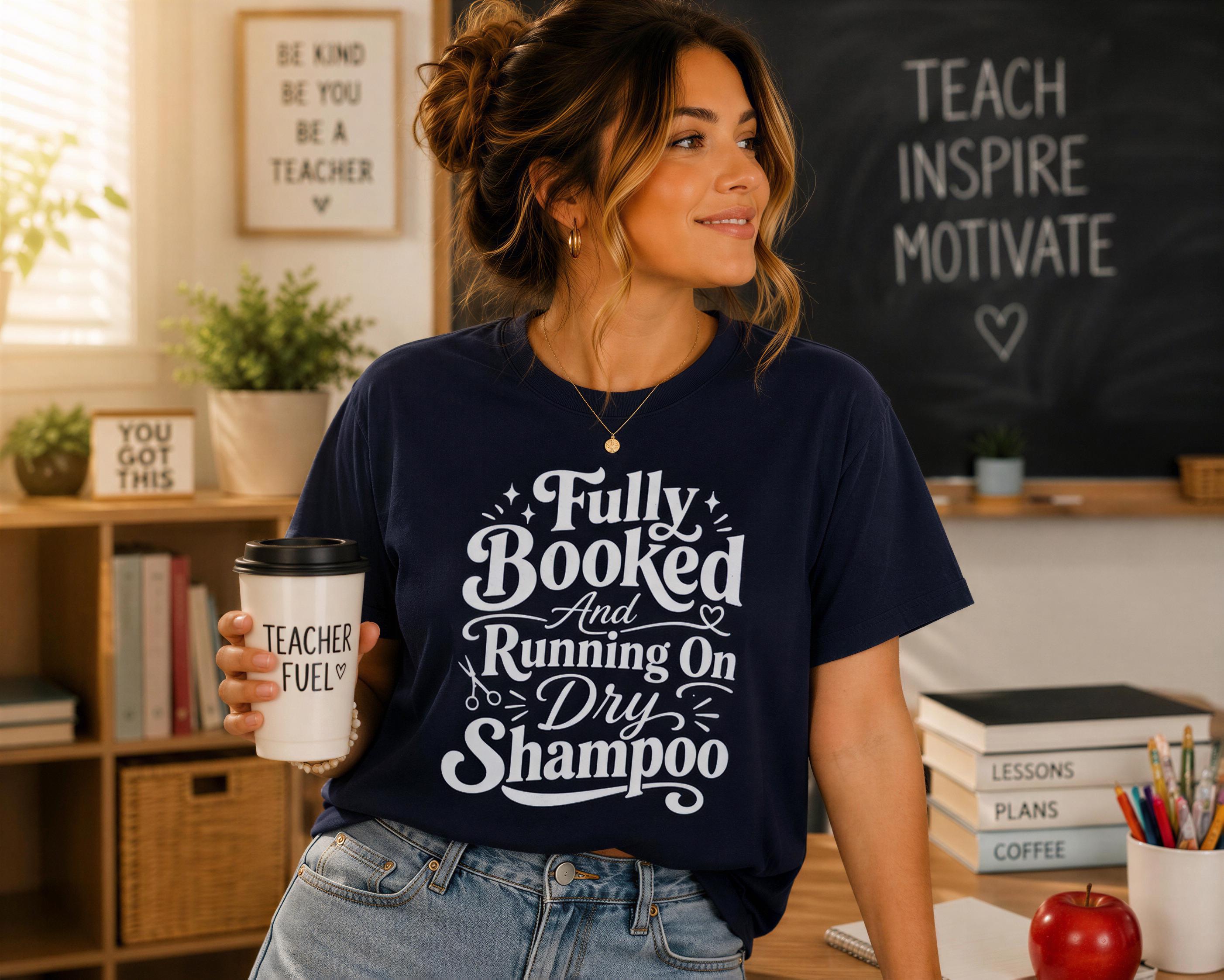 A woman wearing a navy blue t-shirt with text and holding a coffee cup stands in front of a chalkboard with motivational messages.