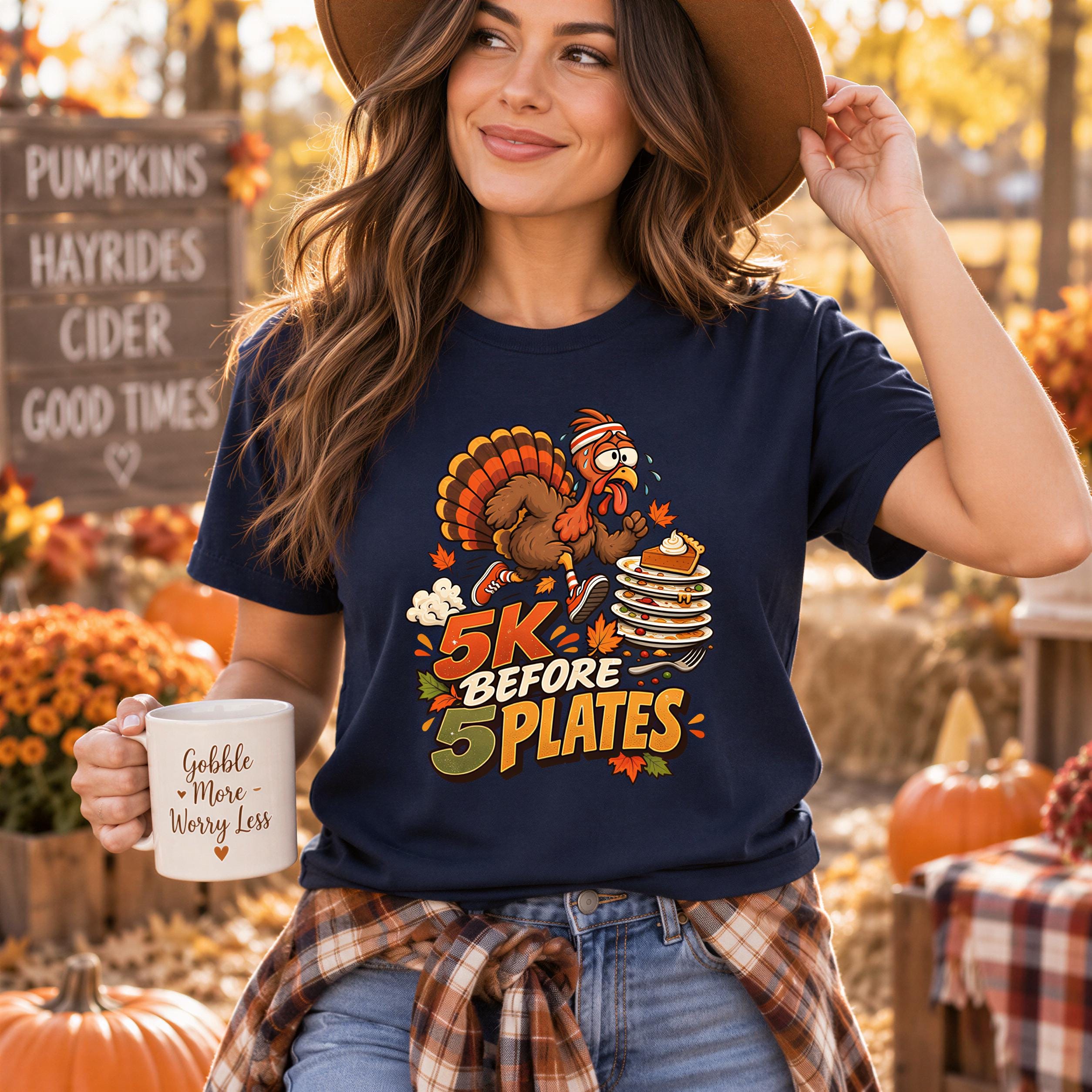 A woman wearing a blue t-shirt with a turkey graphic and the text "5k before 5 plates" is holding a coffee mug and smiling.