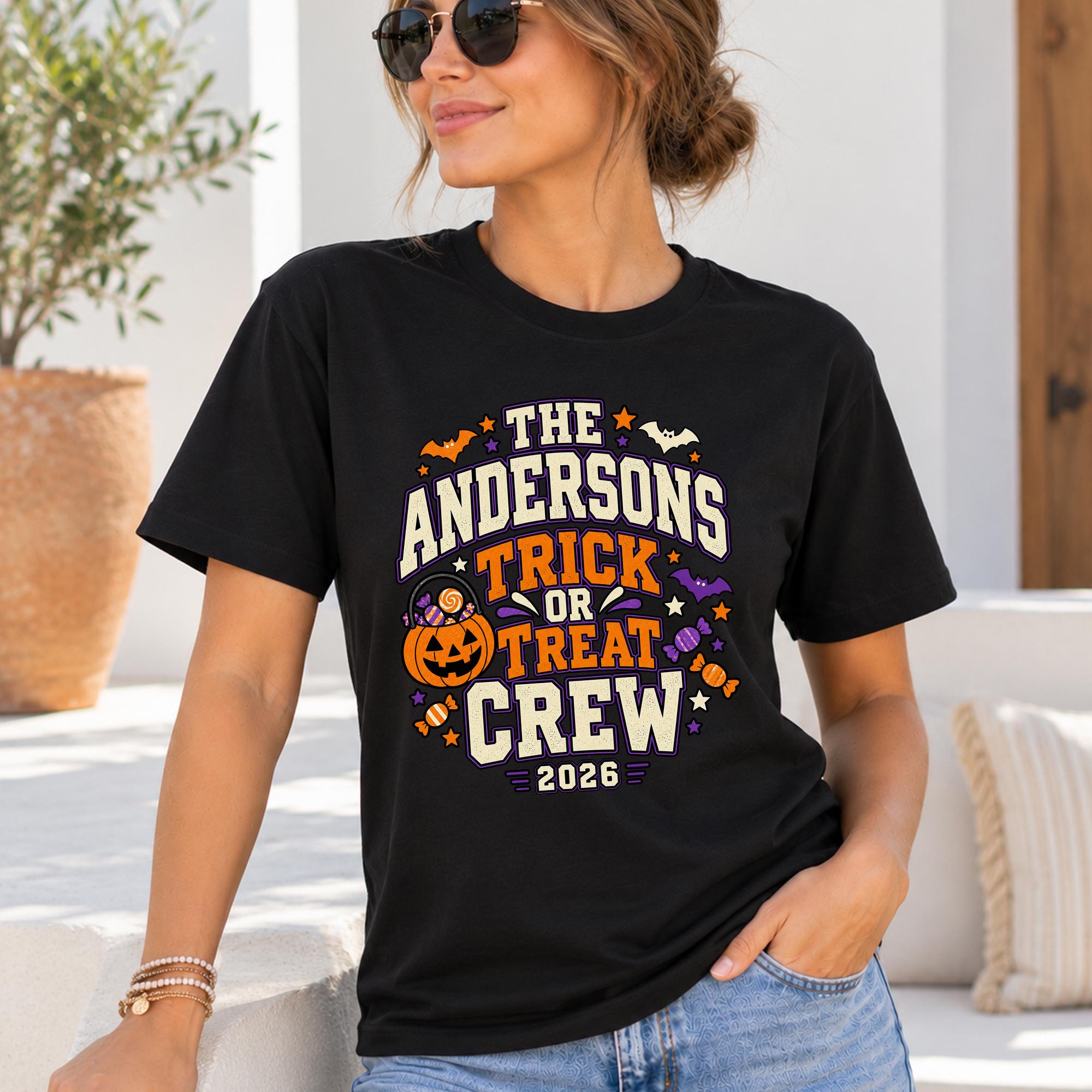 A woman wearing a black t-shirt with a Halloween-themed graphic design, including a pumpkin, bats, and candy canes.