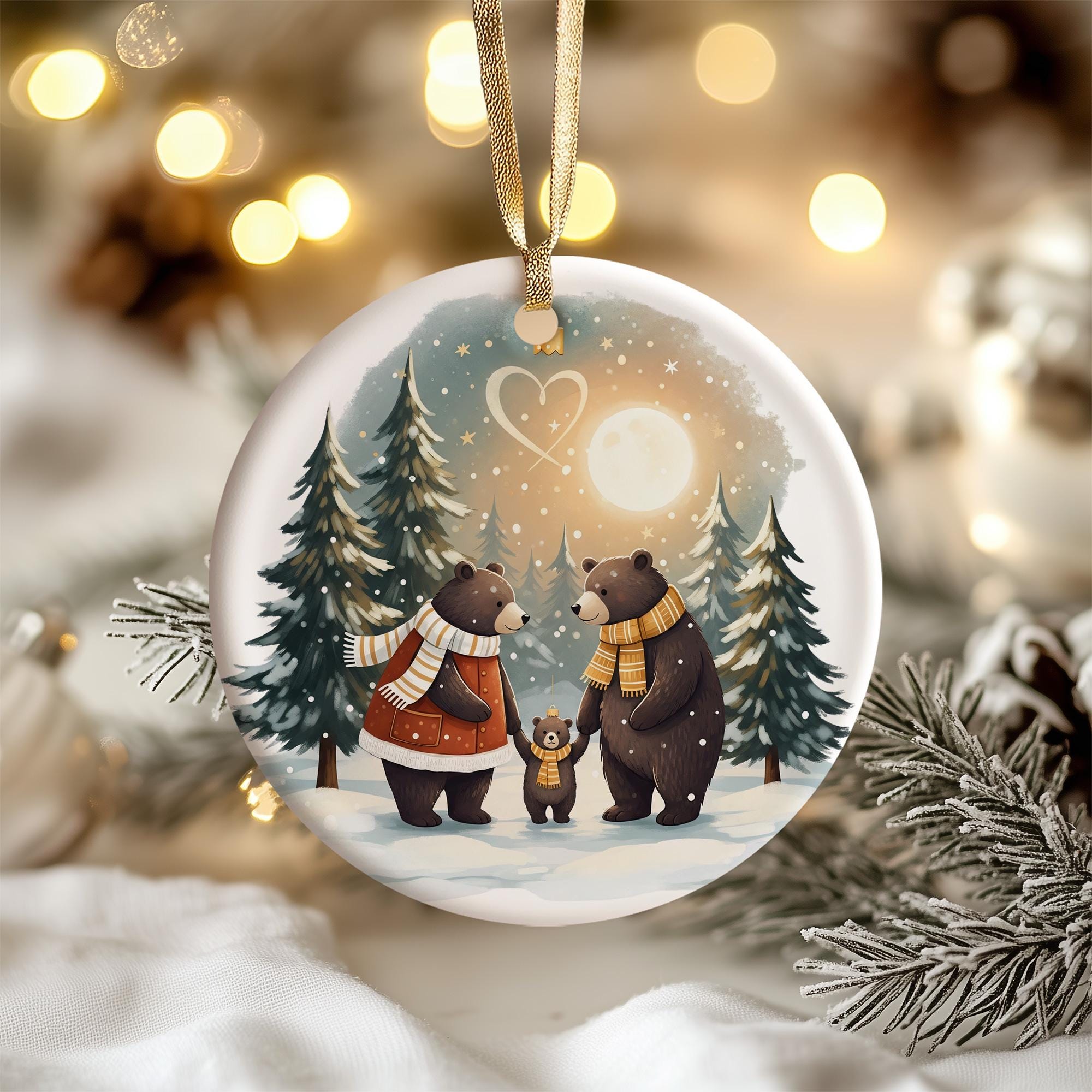 A white oval ornament hanging on a Christmas tree, depicting a family of bears in a snowy forest under a starry night sky.