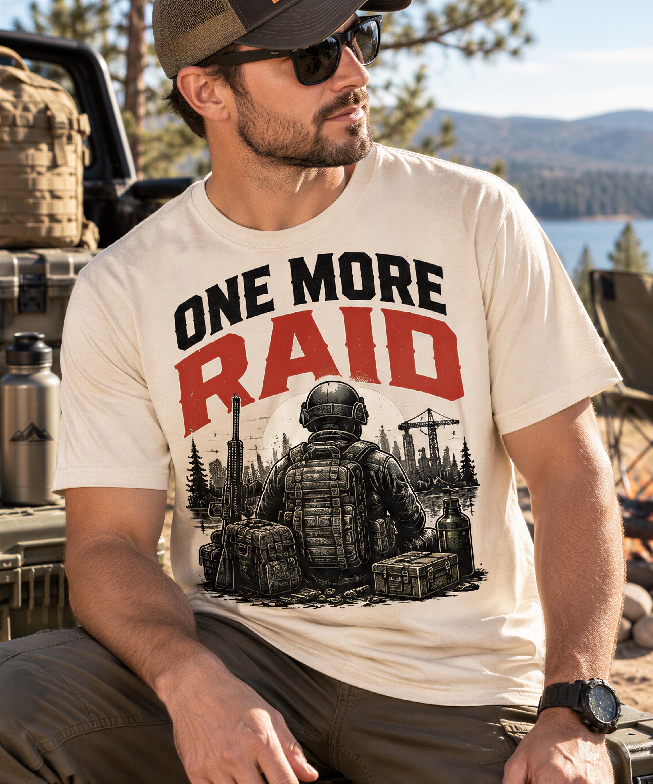 A man wearing a t-shirt with a graphic design of a soldier in a combat uniform, along with the text "ONE MORE RAID" and an illustration of a cityscape.
