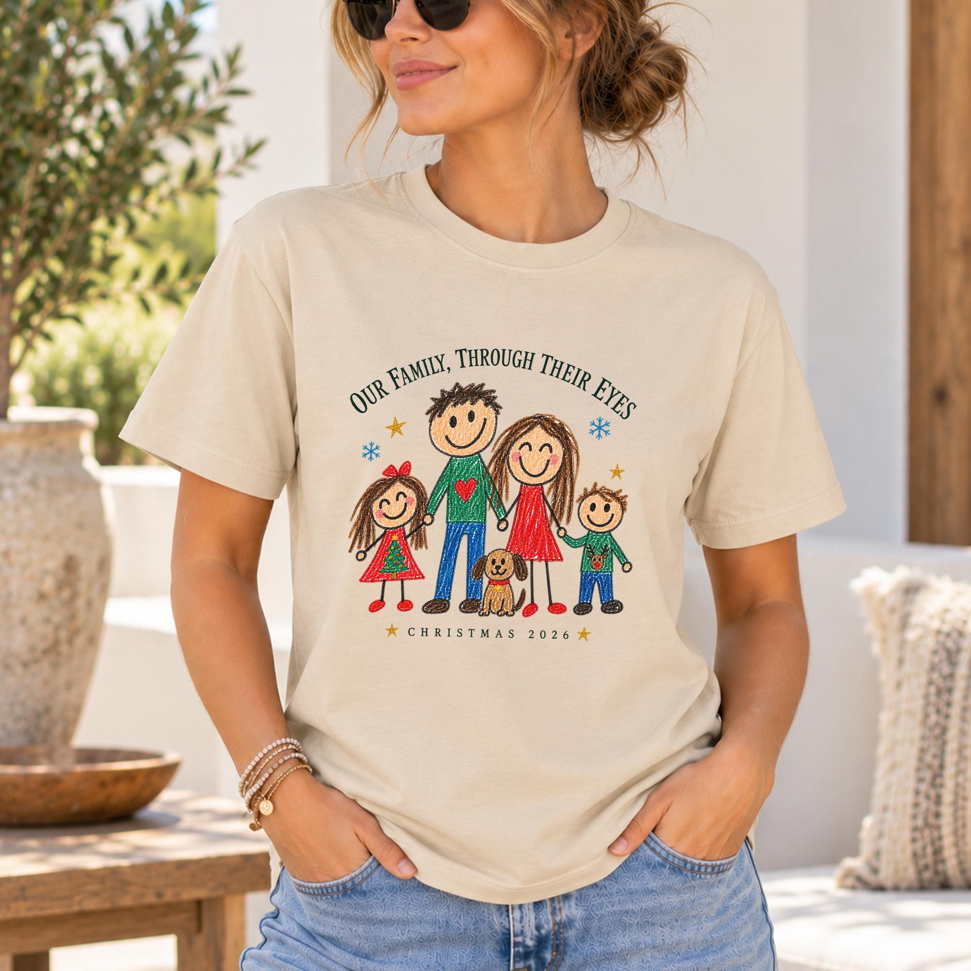 A woman wearing a t-shirt with a drawing of a family and the text "Our Family. Through Their Eyes" and "Christmas 2020" printed on it.