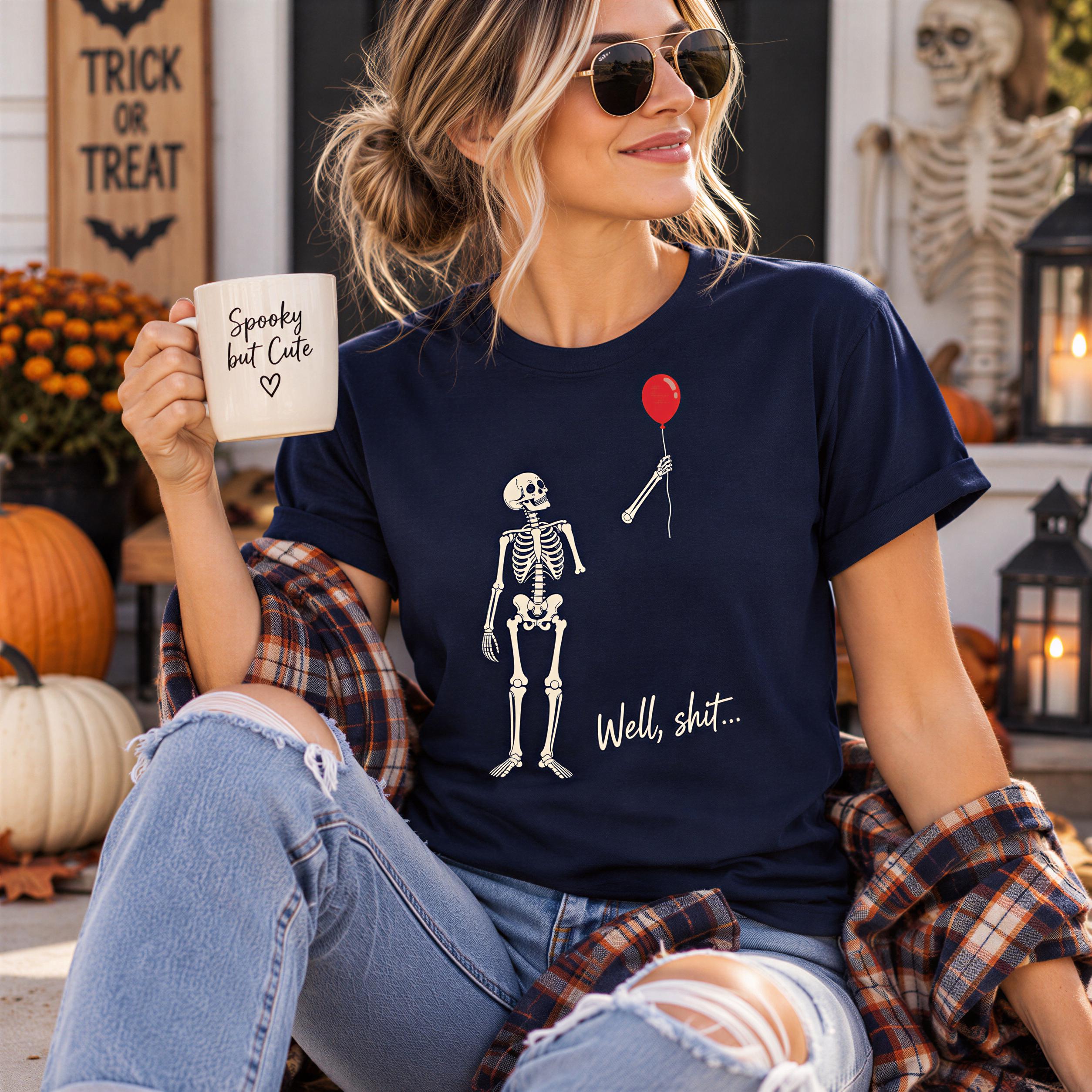 A woman wearing a blue t-shirt with a skeleton graphic and holding a coffee mug with the text "Spooky but Cute" printed on it.