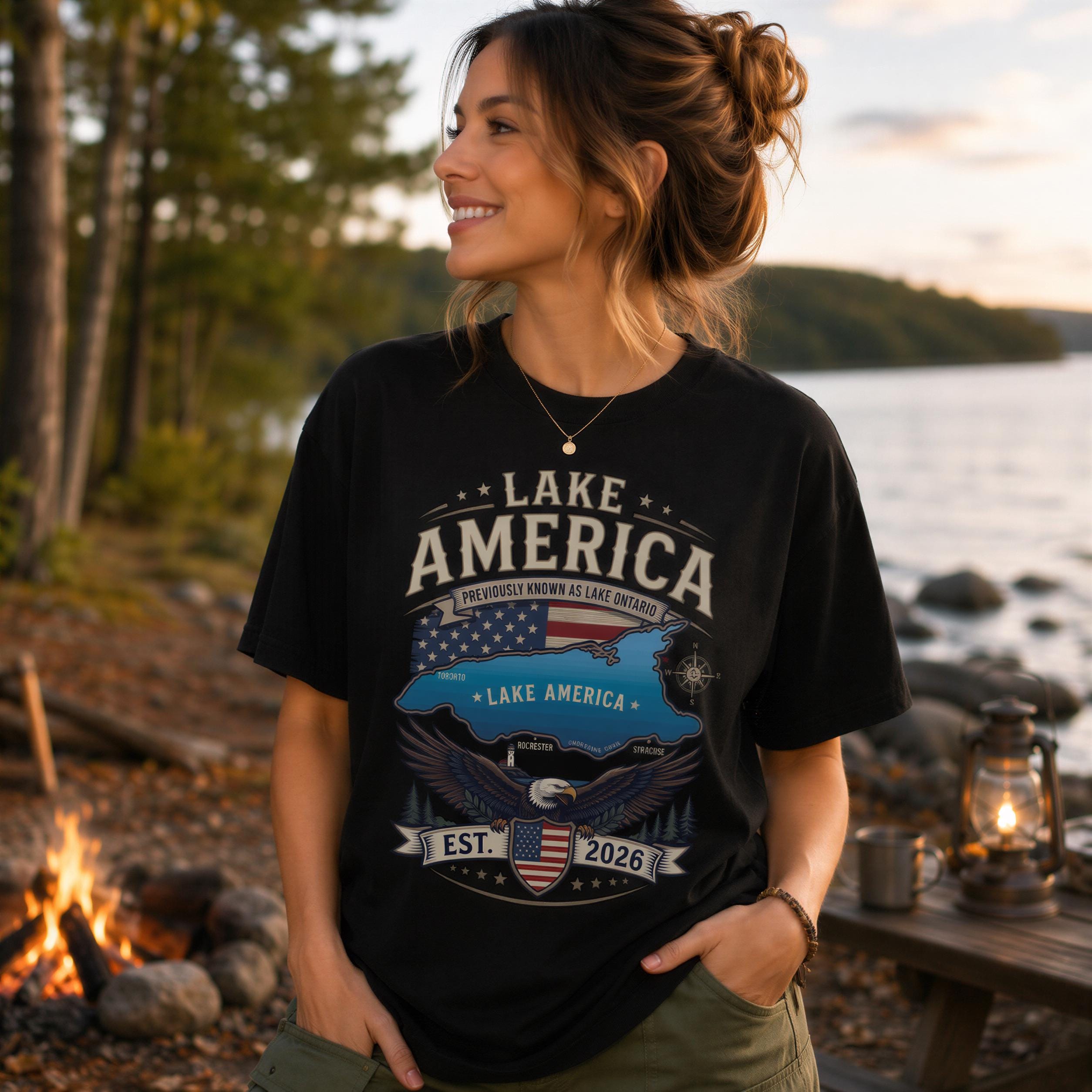 A woman wearing a black t-shirt with a graphic design of an eagle and the text "Lake America" standing near a lake.