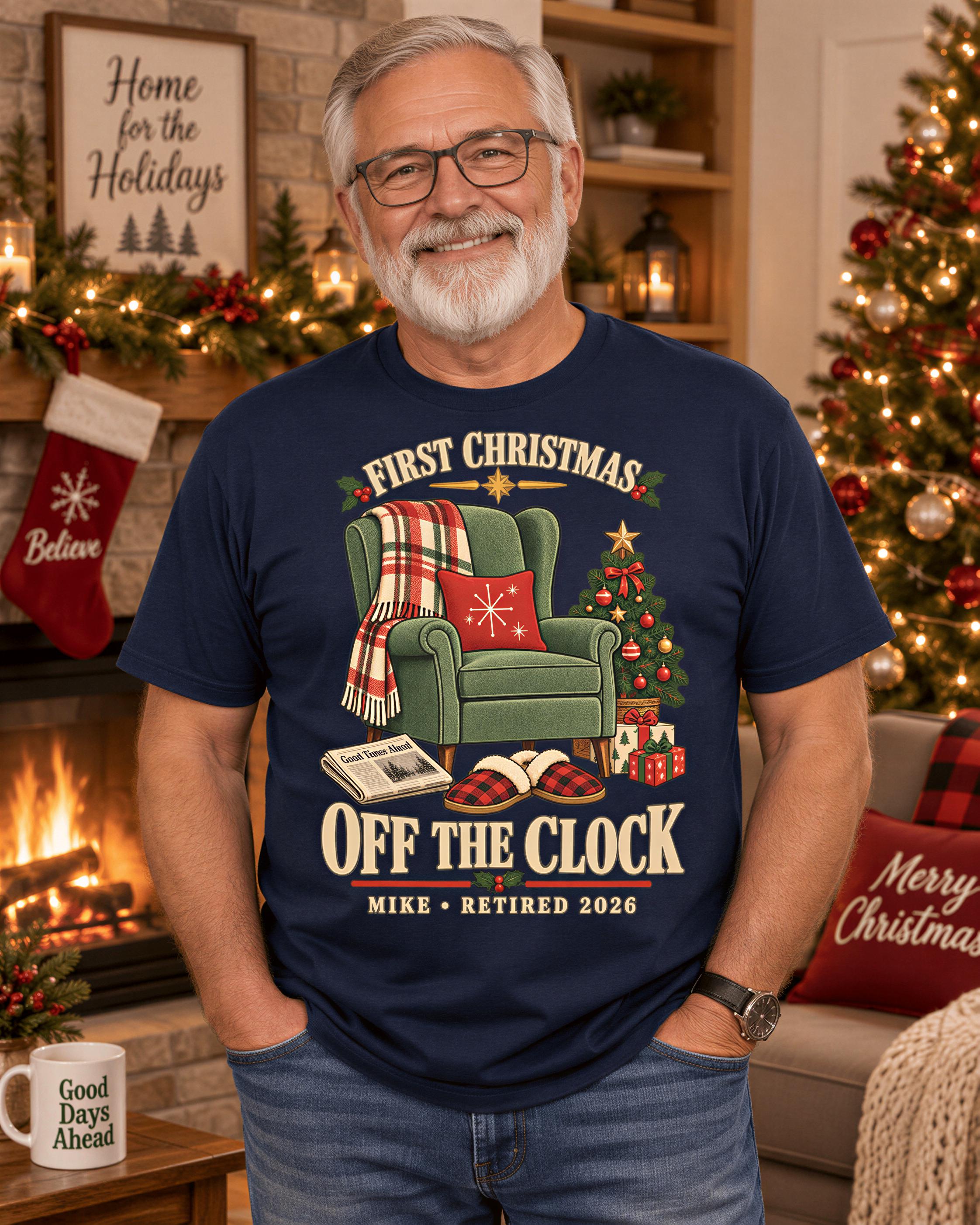 A man wearing a blue t-shirt with a Christmas-themed graphic stands in front of a fireplace with a Christmas tree and stockings.