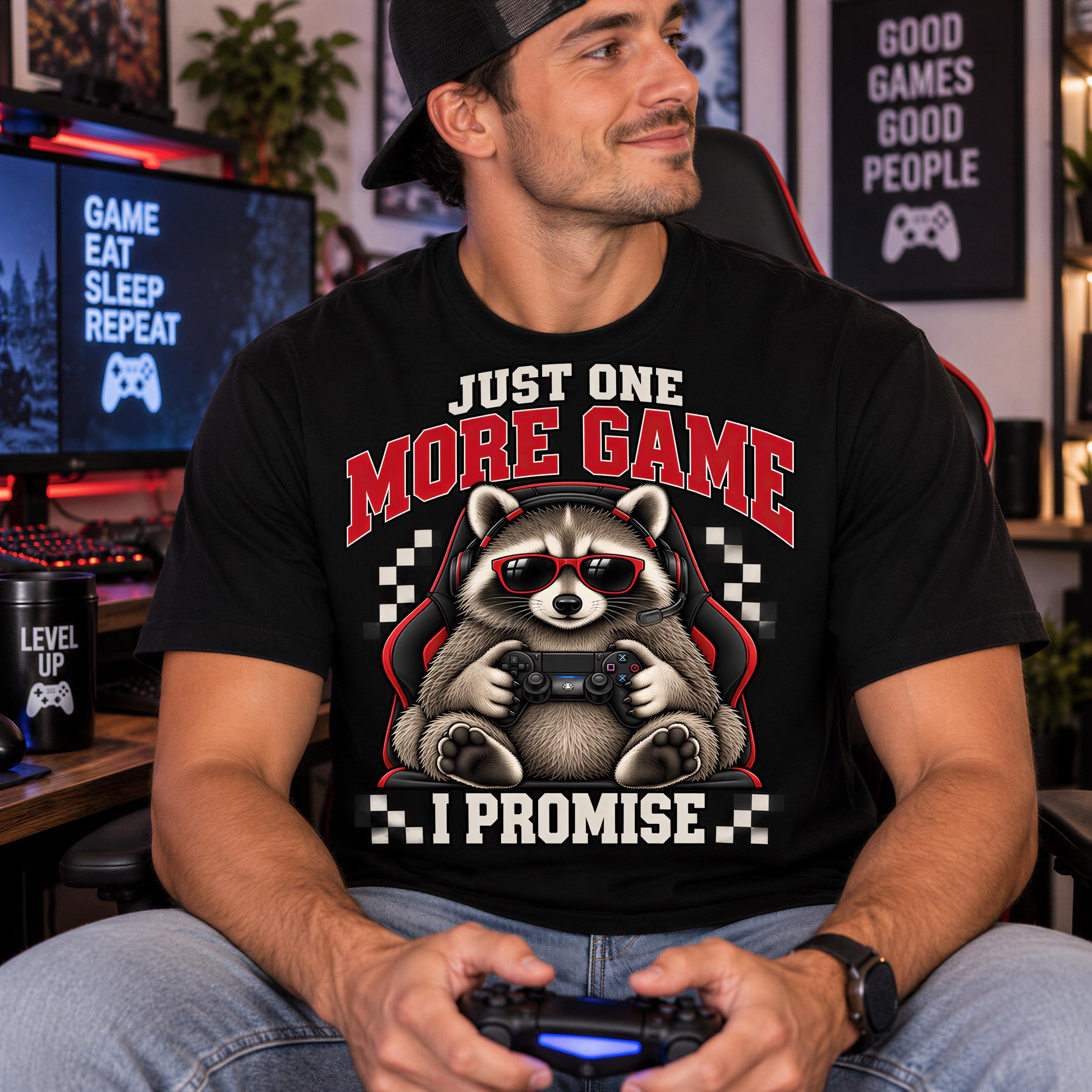 A man wearing a black t-shirt with a graphic of a raccoon playing a video game, holding a game controller, and smiling.