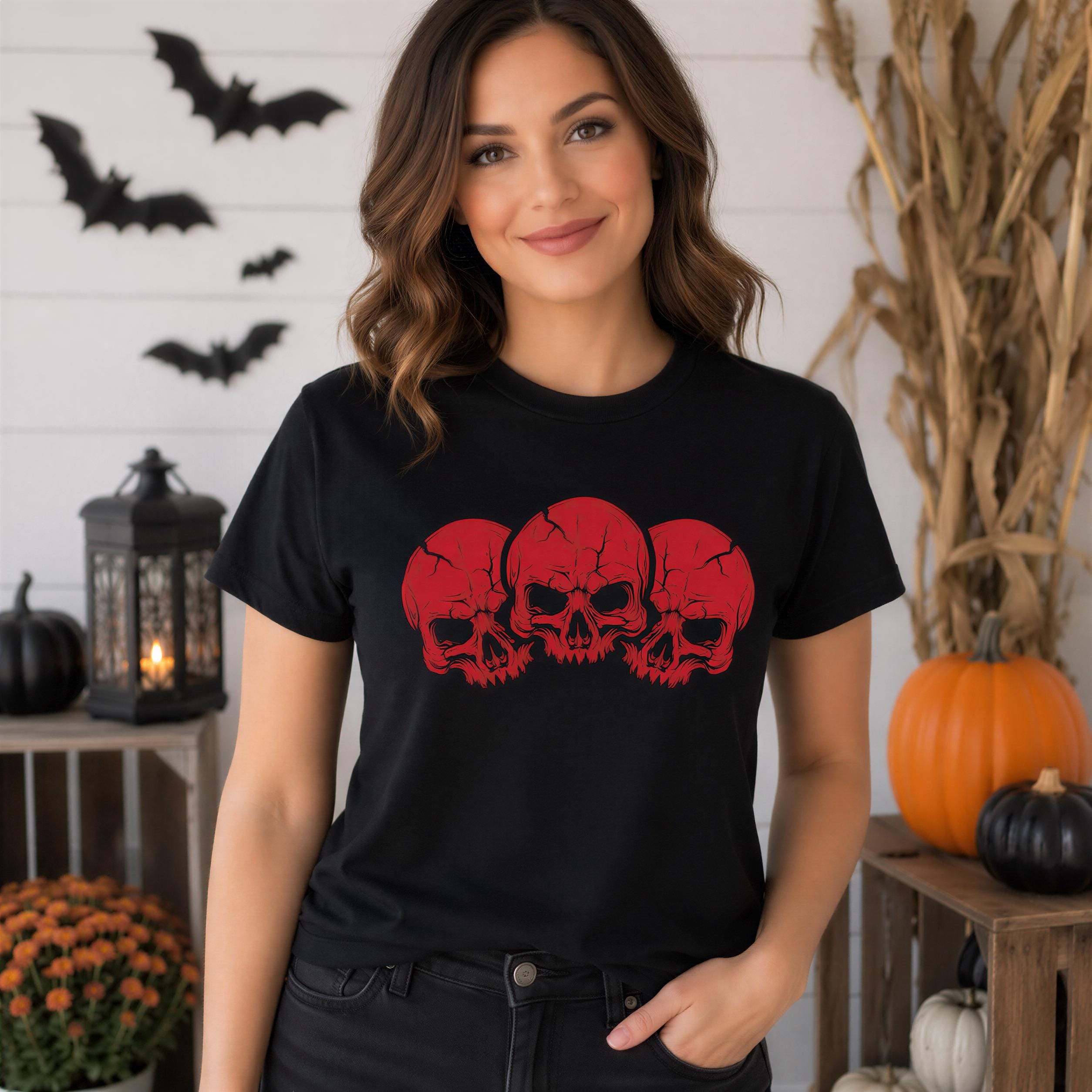A woman wearing a black t-shirt with red skull designs stands in front of a Halloween-themed backdrop, including bats, pumpkins, and a lantern.