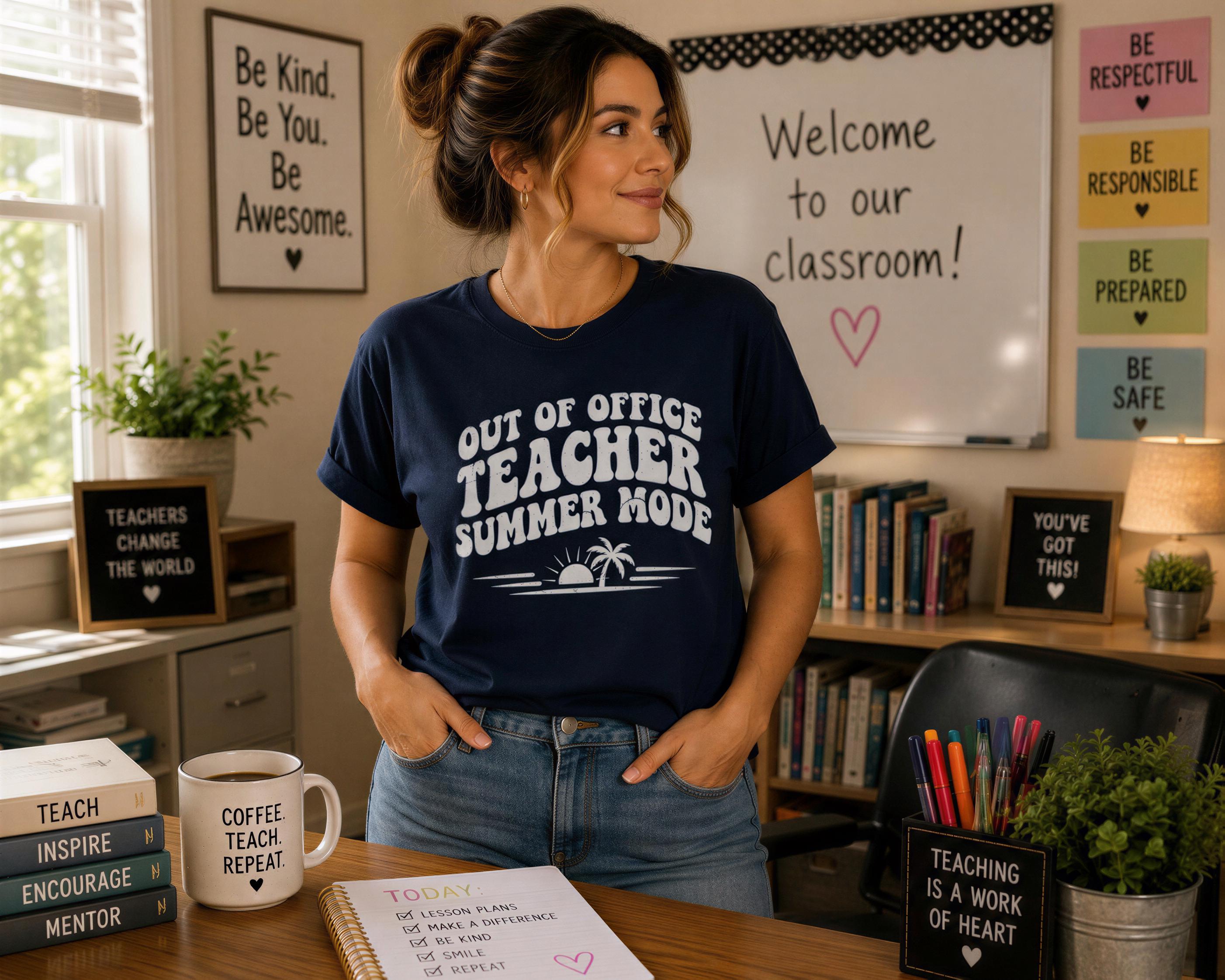 A woman wearing a blue t-shirt with a humorous message stands in a classroom setting, surrounded by various educational materials and decorations.