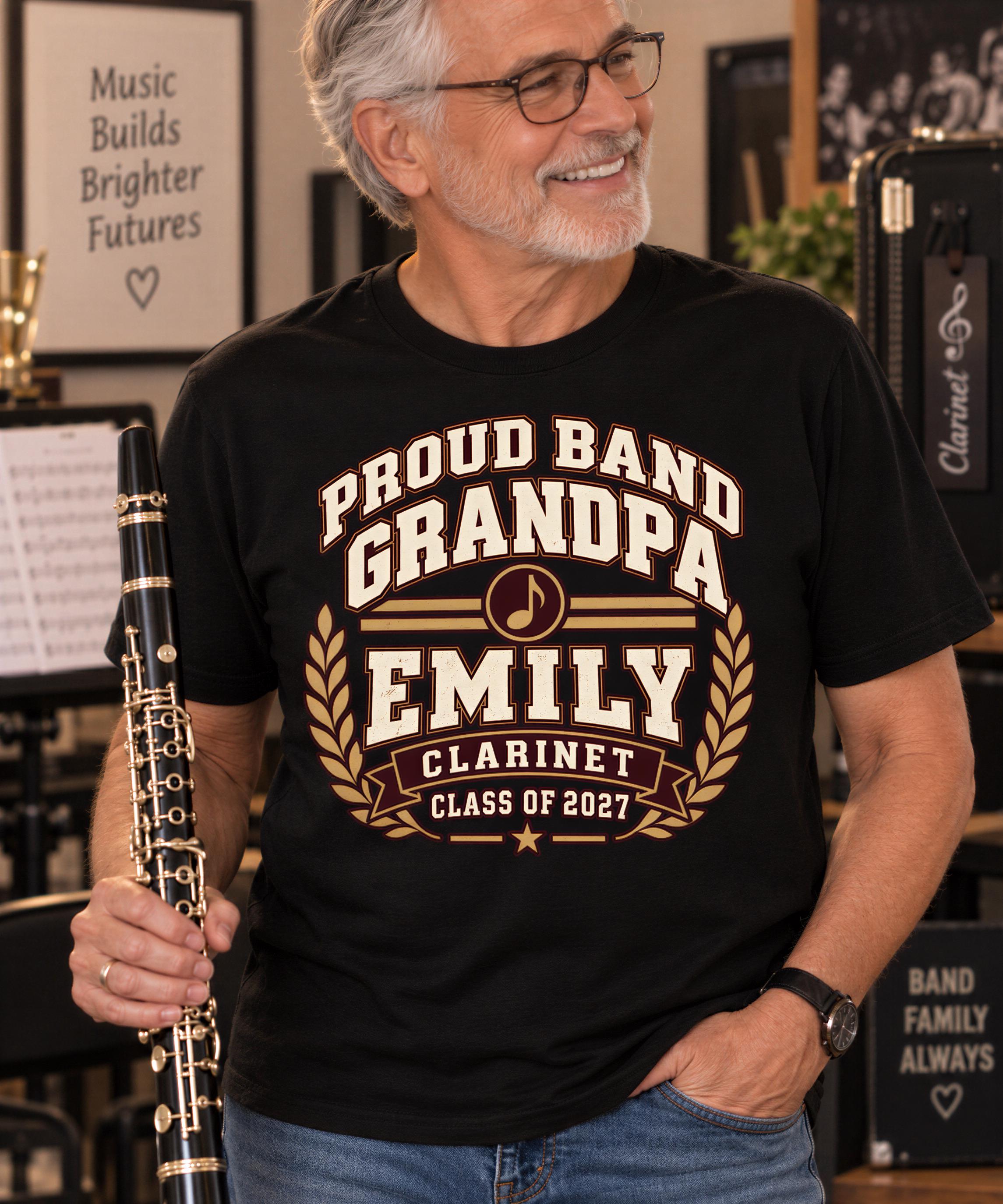 A smiling older man wearing a black t-shirt with text and a harp stands in a room with musical instruments and sheet music visible in the background.