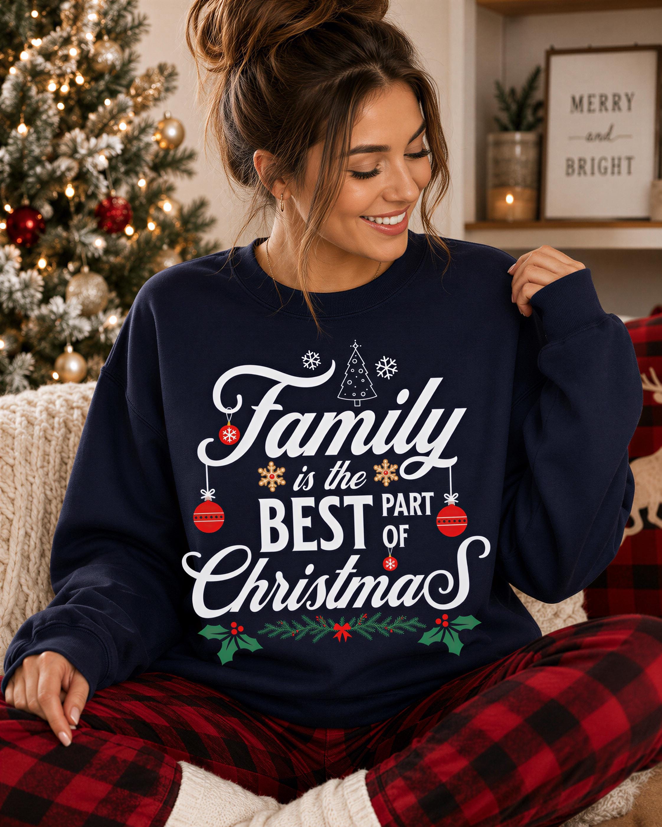 A woman wearing a navy blue sweatshirt with the text "Family is the best part of Christmas" is sitting in front of a Christmas tree.