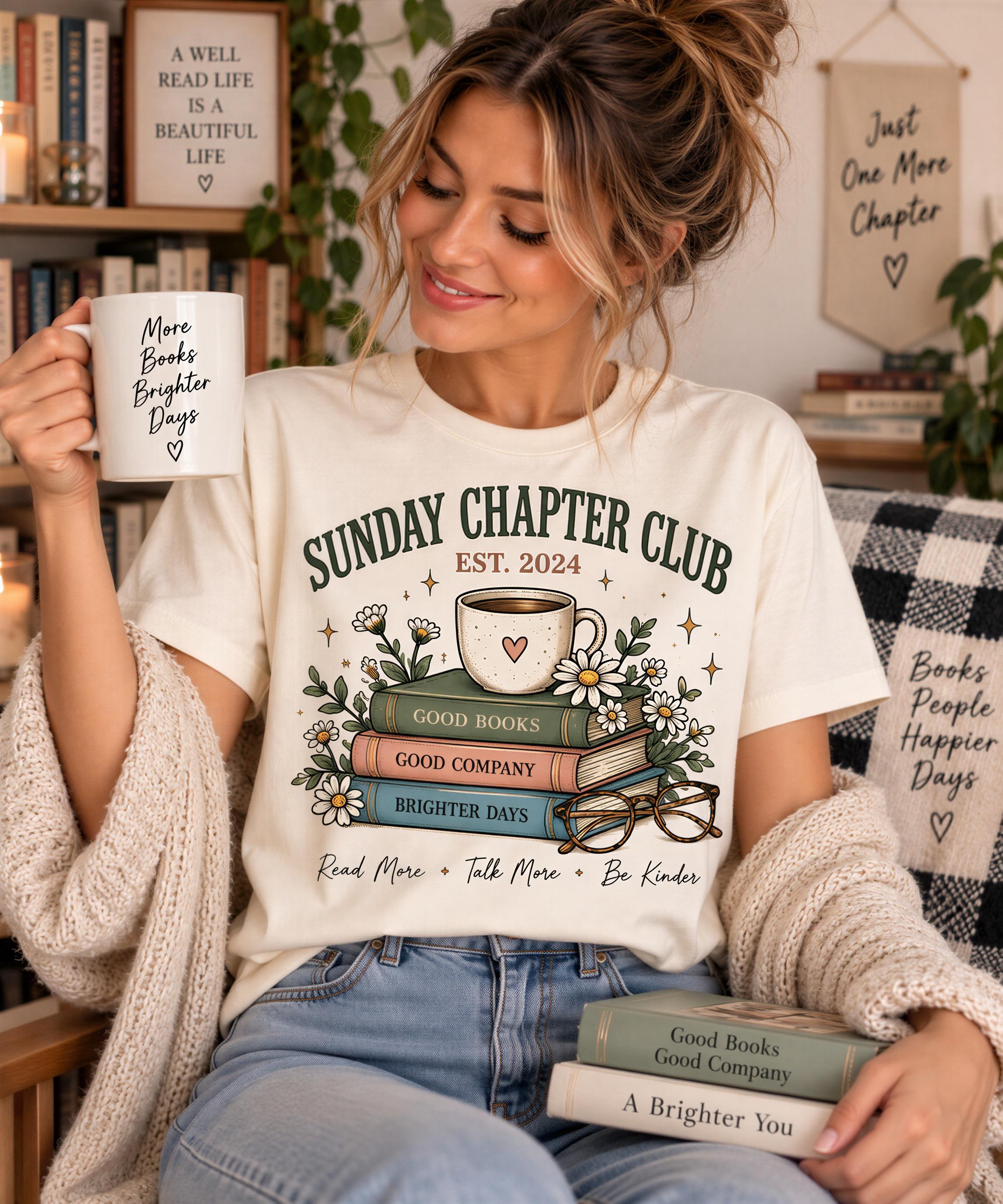 A woman wearing a white t-shirt with a graphic design of books and flowers, holding a coffee mug and smiling.
