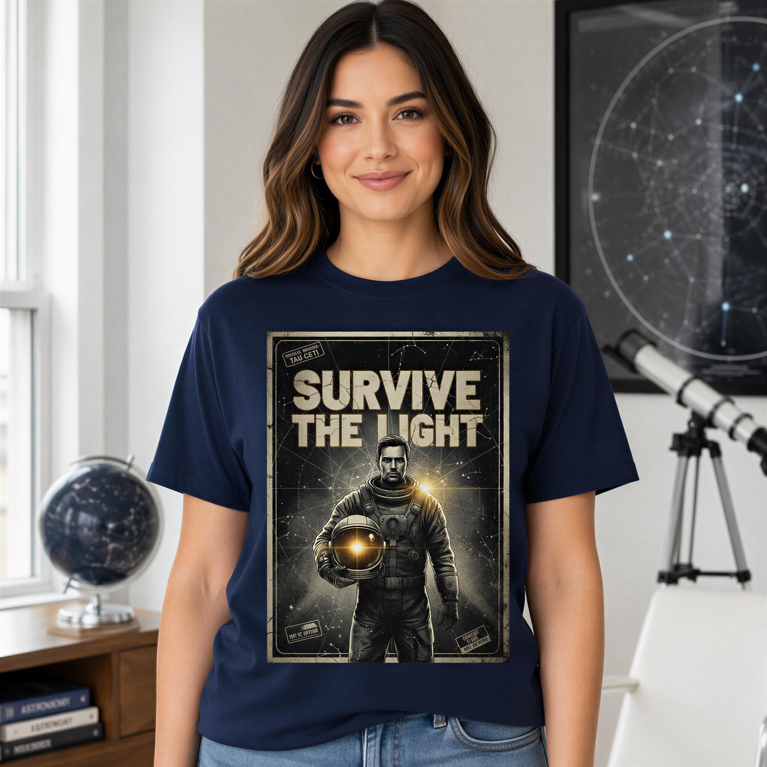 A woman wearing a navy blue t-shirt with a graphic design of a person in a spacesuit and the text "SURVIVE THE LIGHT" printed on it.