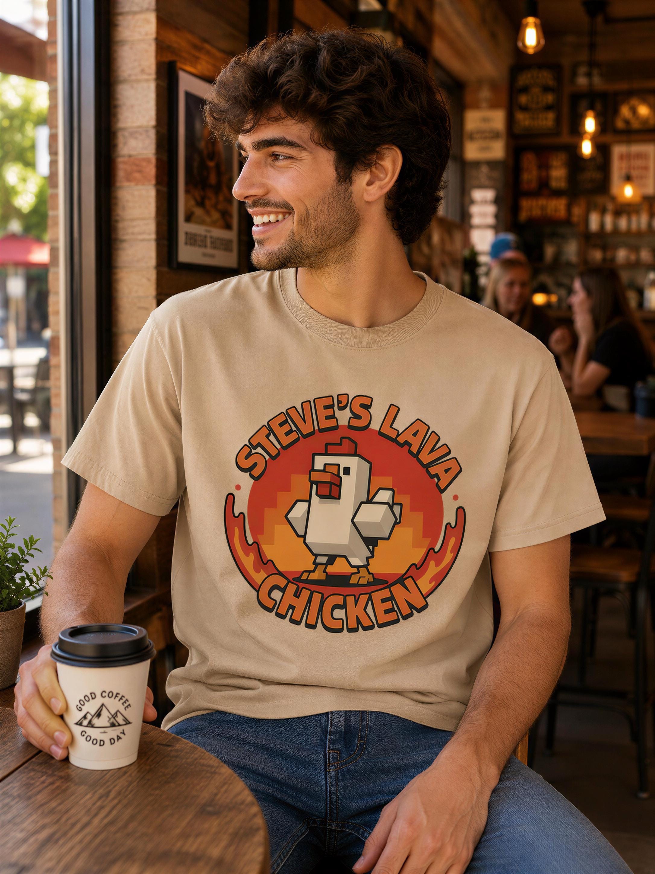 A man wearing a t-shirt with a graphic of a chicken and the text "STEVE'S LAVA CHICKEN" is sitting at a table in a restaurant, holding a coffee cup.