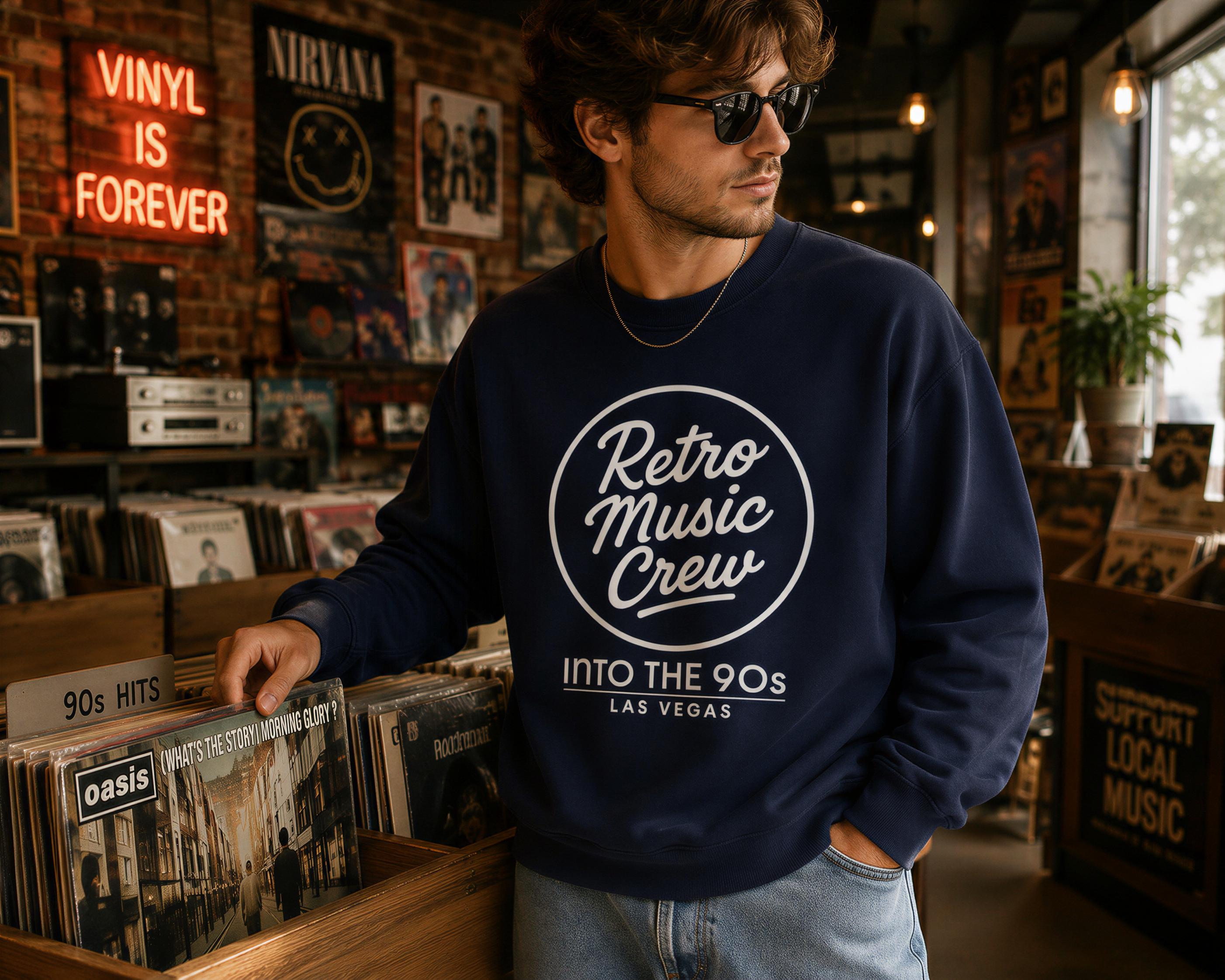 A man in a navy blue sweatshirt with the text "Retro Music Crew" is browsing through vinyl records in a record store.