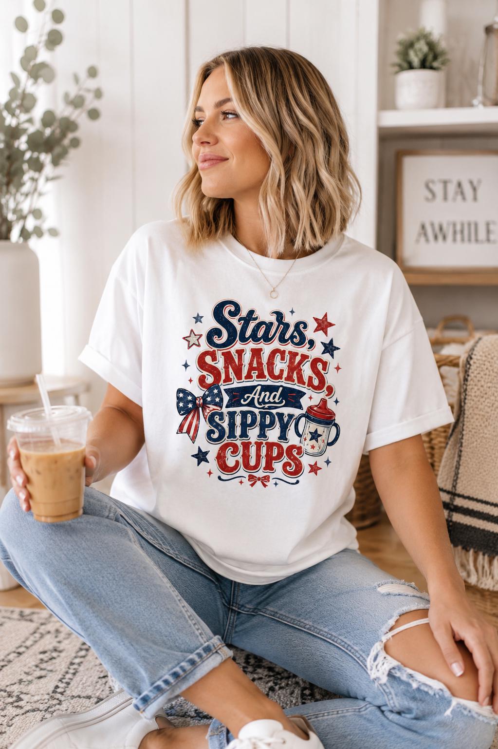 A woman wearing a white t-shirt with a patriotic design and holding a drink is sitting on the floor in a room with a potted plant and a framed sign.