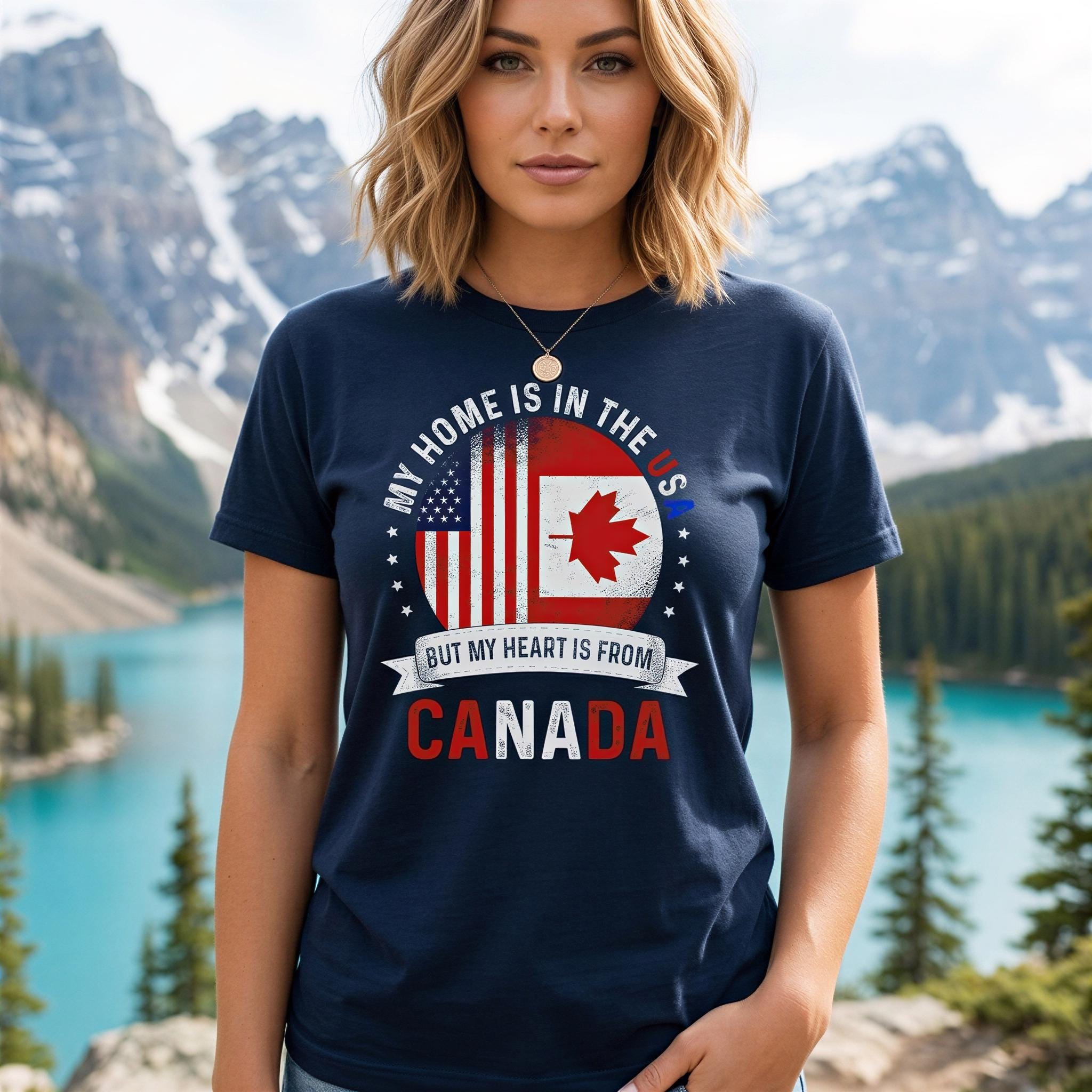 A woman wearing a navy blue t-shirt with a graphic design that says "My home is in the US, but my heart is from Canada" and features an American flag and a maple leaf.