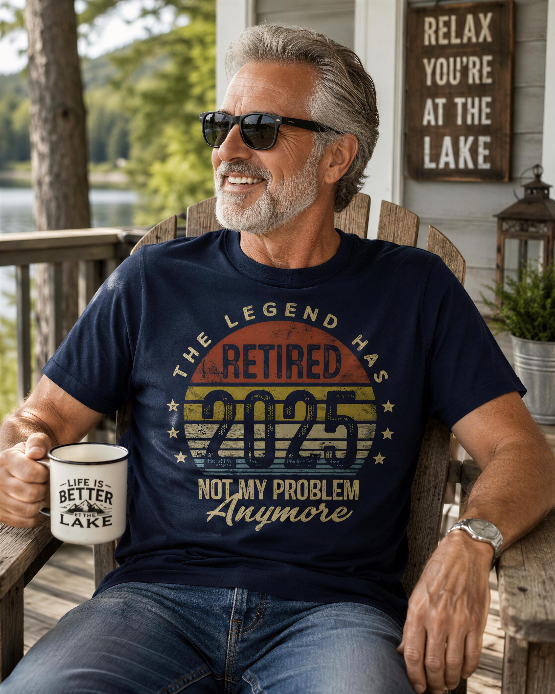 A man wearing a blue t-shirt with a humorous text and a mug, sitting on a porch with a lake in the background.