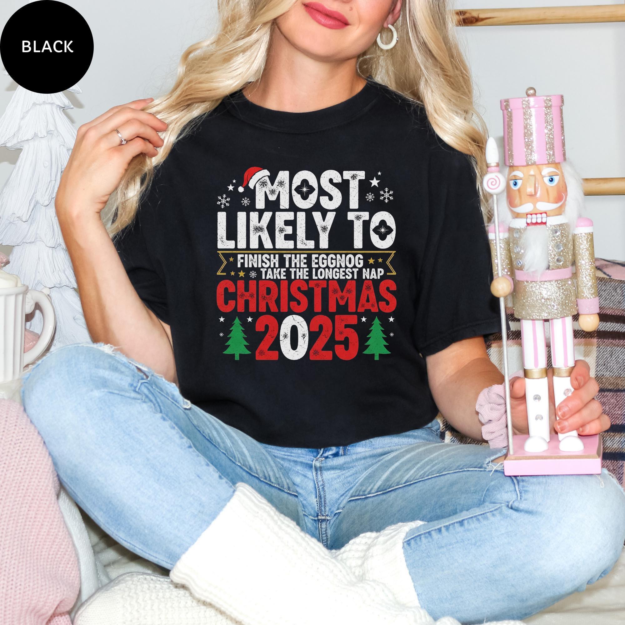 A woman wearing a black t-shirt with a humorous Christmas-themed design, sitting on a couch and holding a nutcracker.
