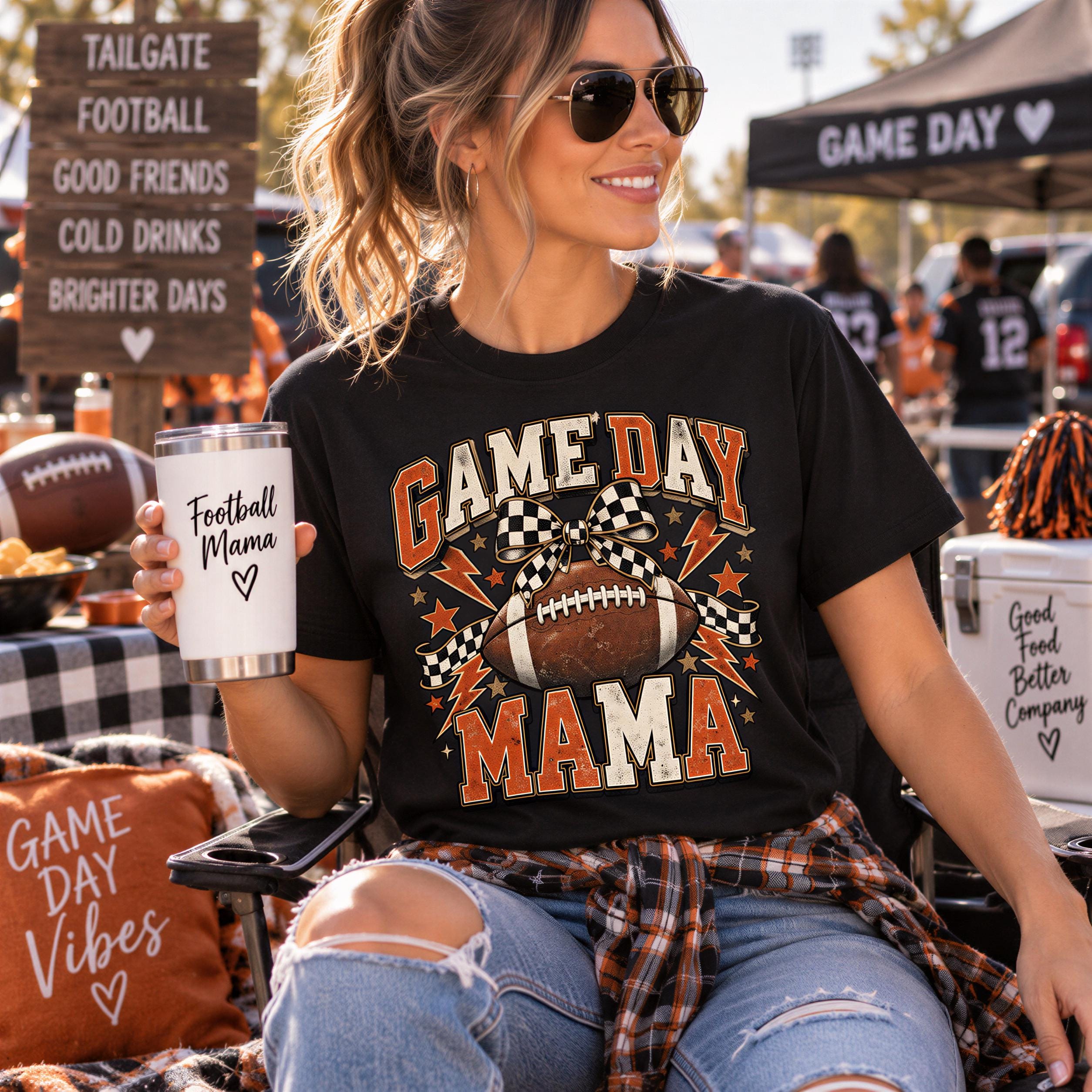 A woman wearing a black t-shirt with a football graphic and the text "GAME DAY MAMA" is sitting outdoors, holding a white cup with a black design and text on it.