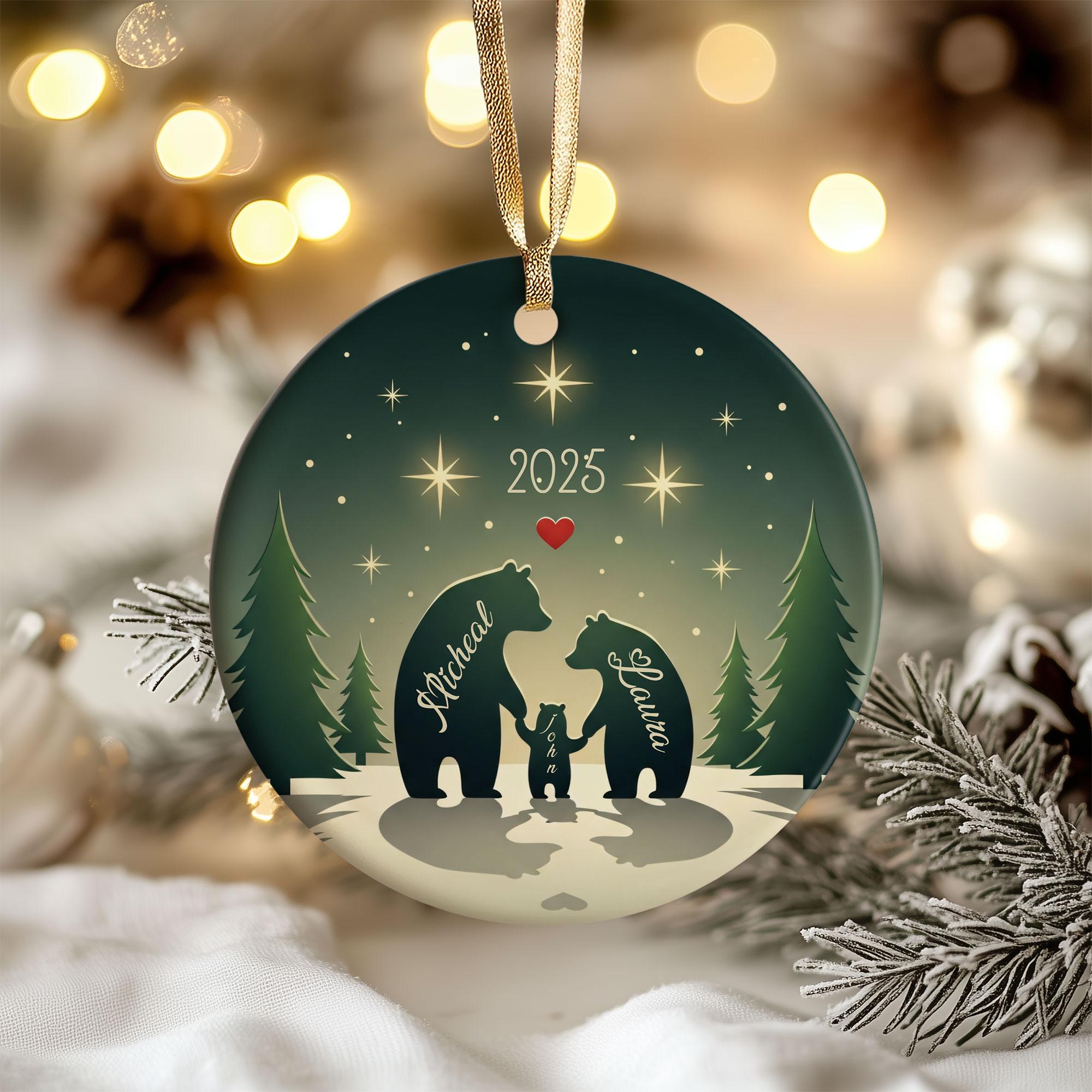 A Christmas ornament featuring silhouettes of three bears, with the names "Michael" and "Lauren" written on them, set against a snowy forest scene with stars.