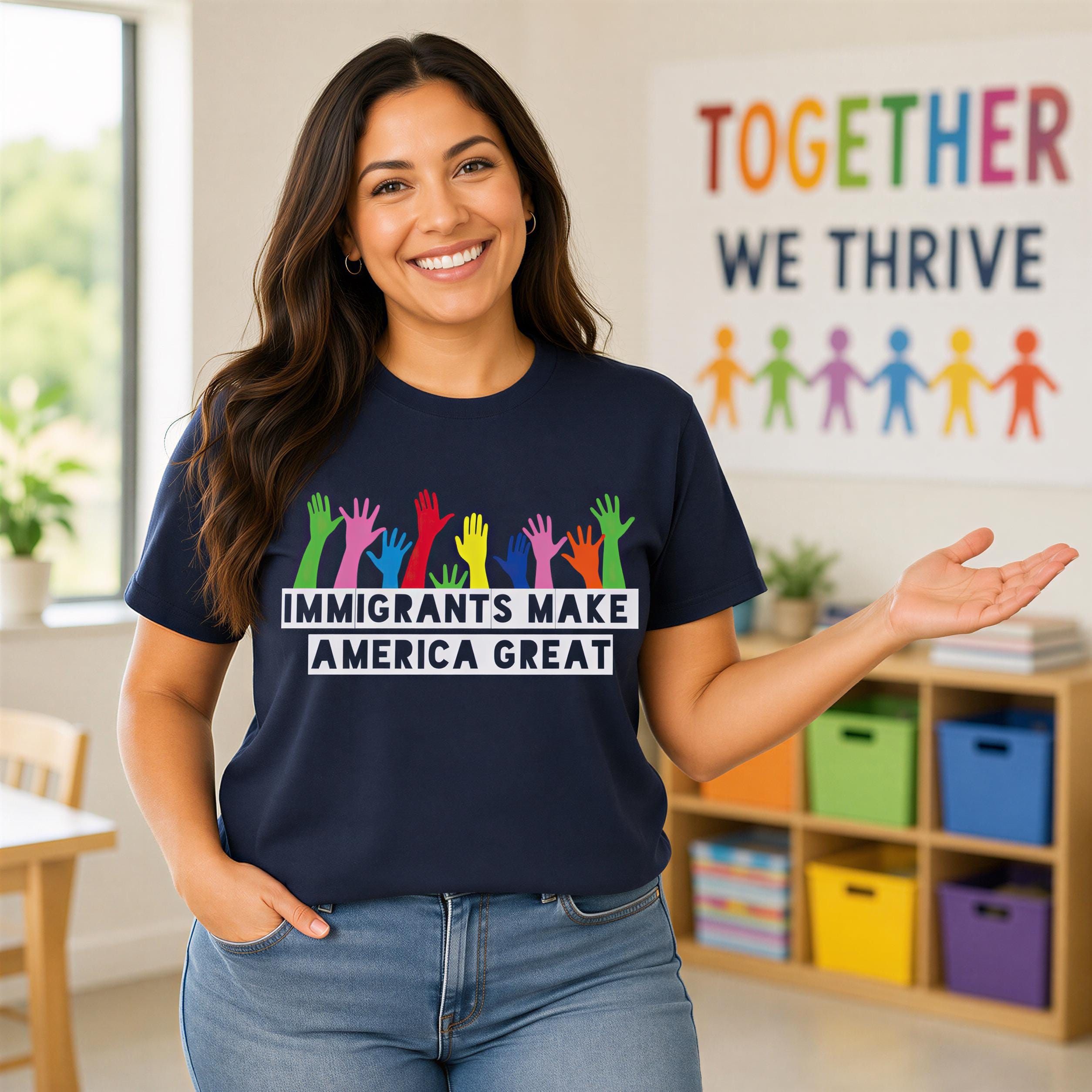 A woman wearing a navy blue t-shirt with a message about immigrants making America great is standing in a room with a colorful poster on the wall behind her.
