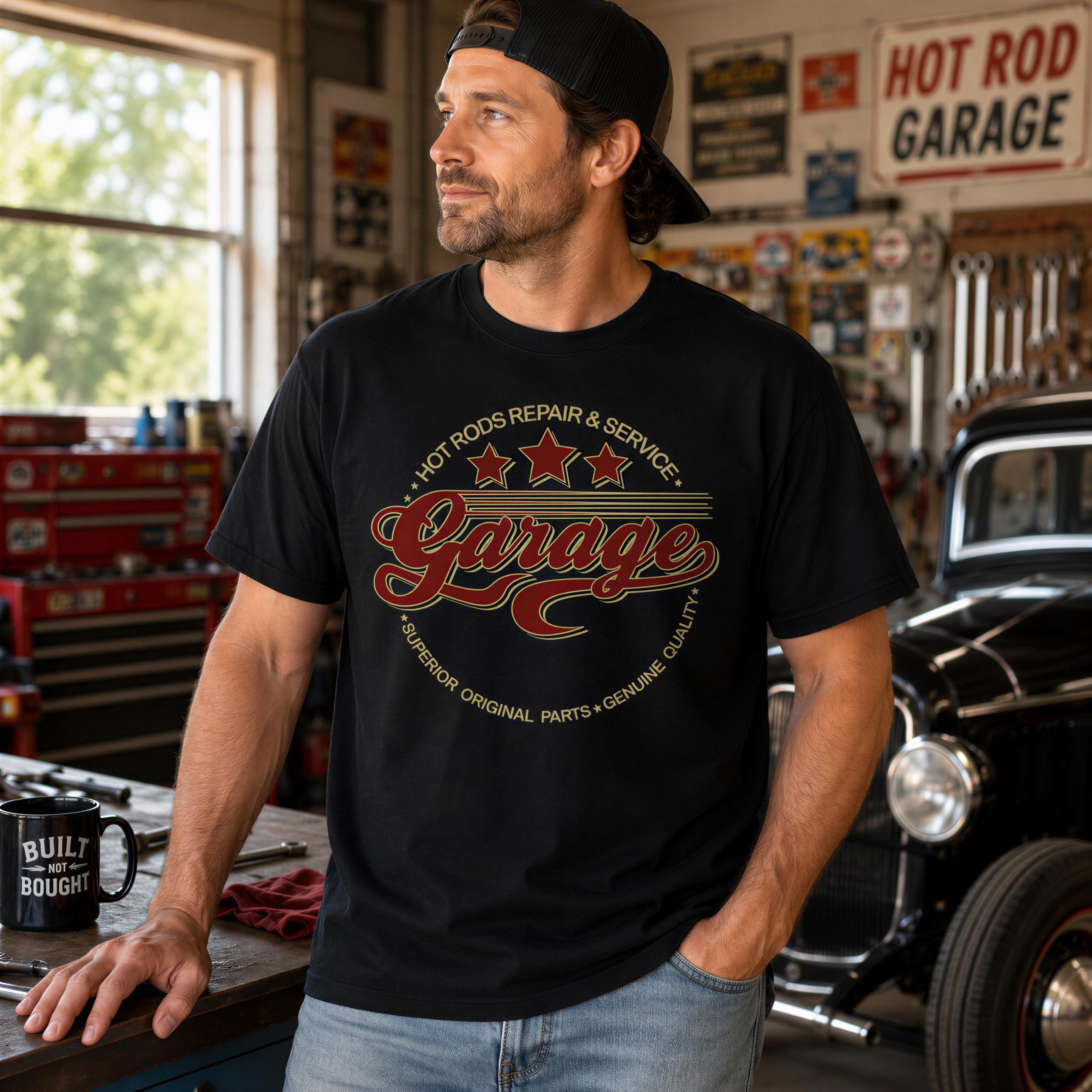 A man wearing a black t-shirt with a graphic design stands in a garage surrounded by various tools and equipment.