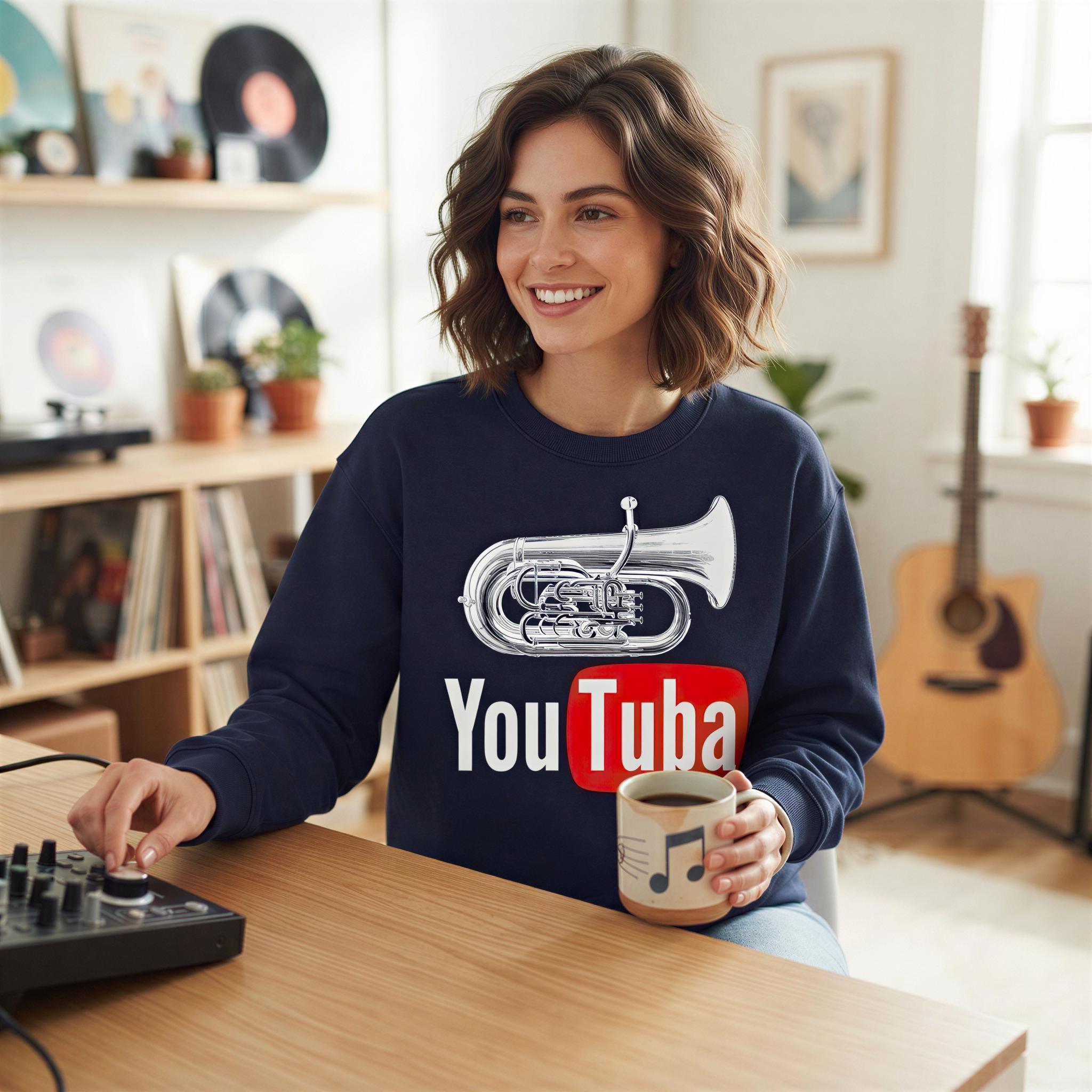 A woman is sitting at a desk, smiling and holding a coffee mug, with a guitar visible in the background.