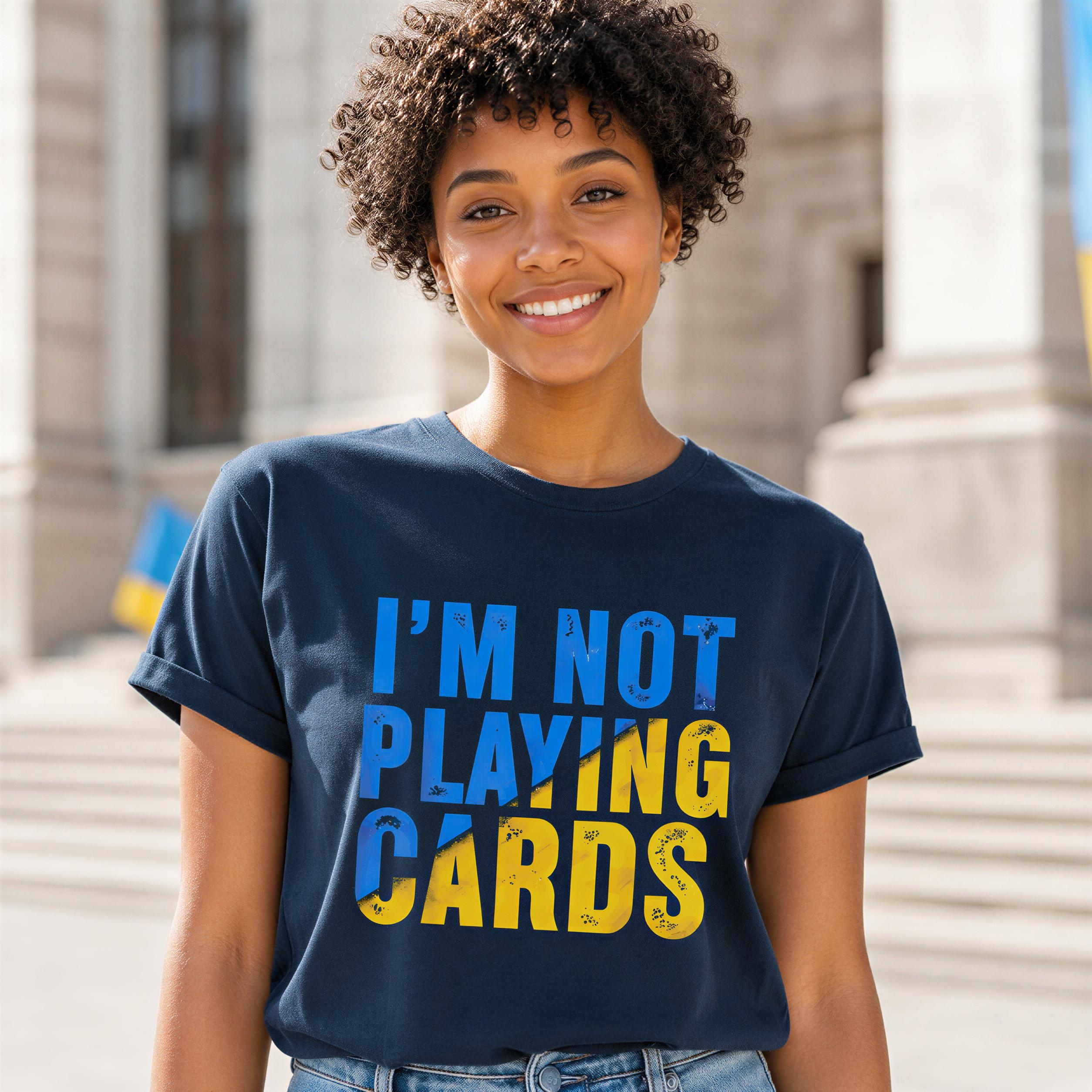 A smiling woman wearing a blue t-shirt with the text "I'M NOT PLAYING CARDS" printed on it.