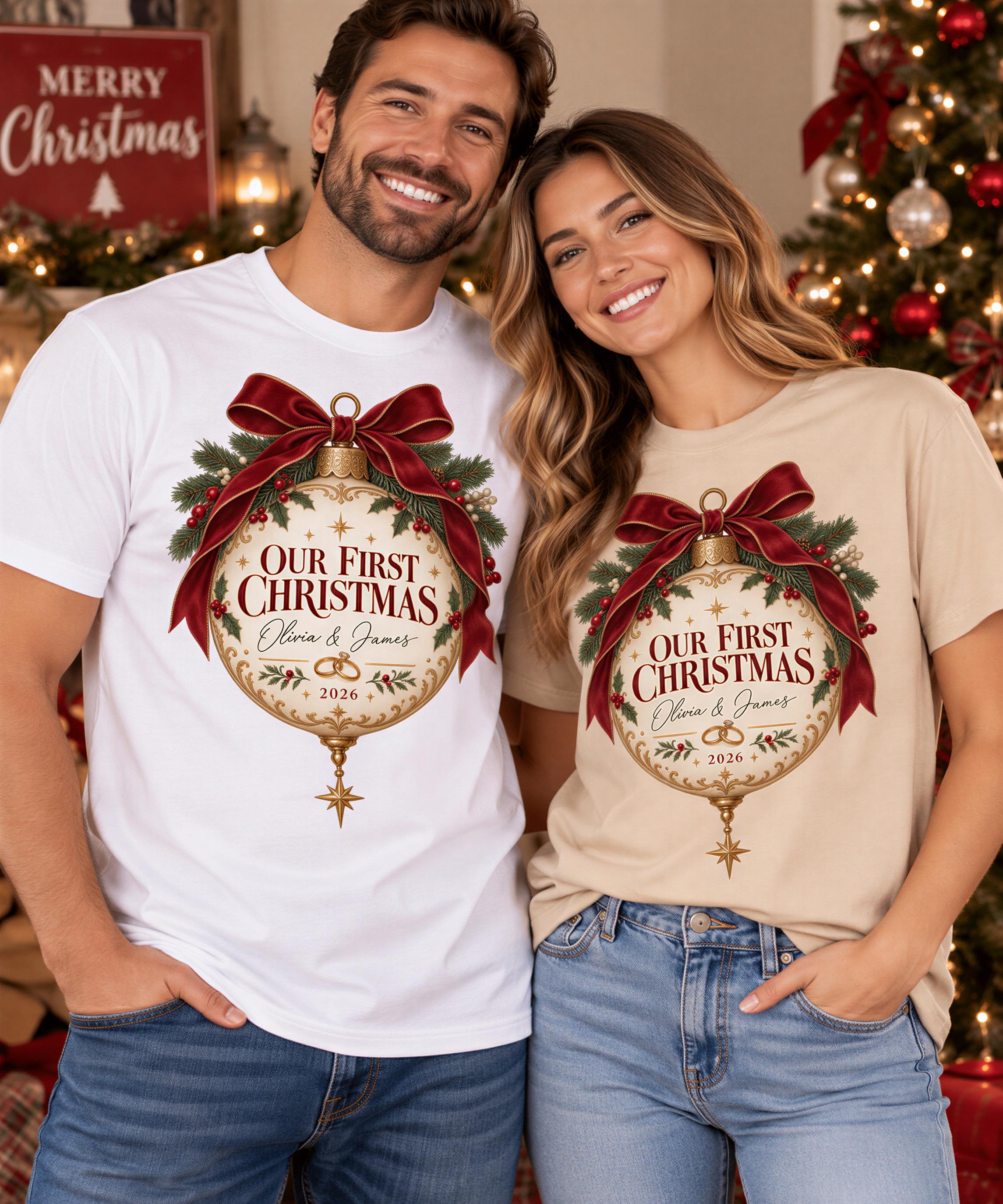 A man and a woman are standing together in front of a Christmas tree, both wearing t-shirts with a festive design.