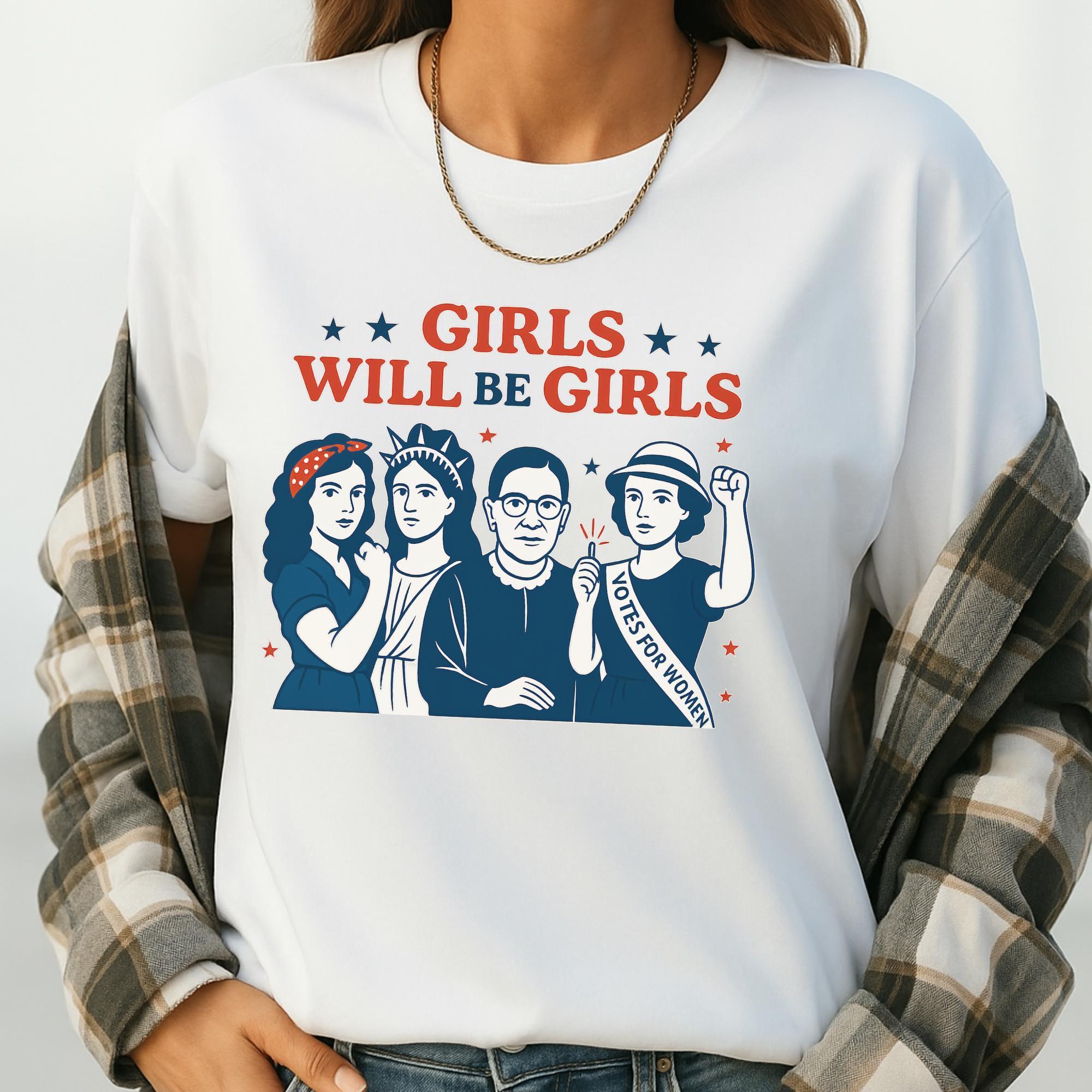 A white t-shirt with a graphic design featuring three women and the text "GIRLS WILL BE GIRLS" along with a "Votes for Women" banner.