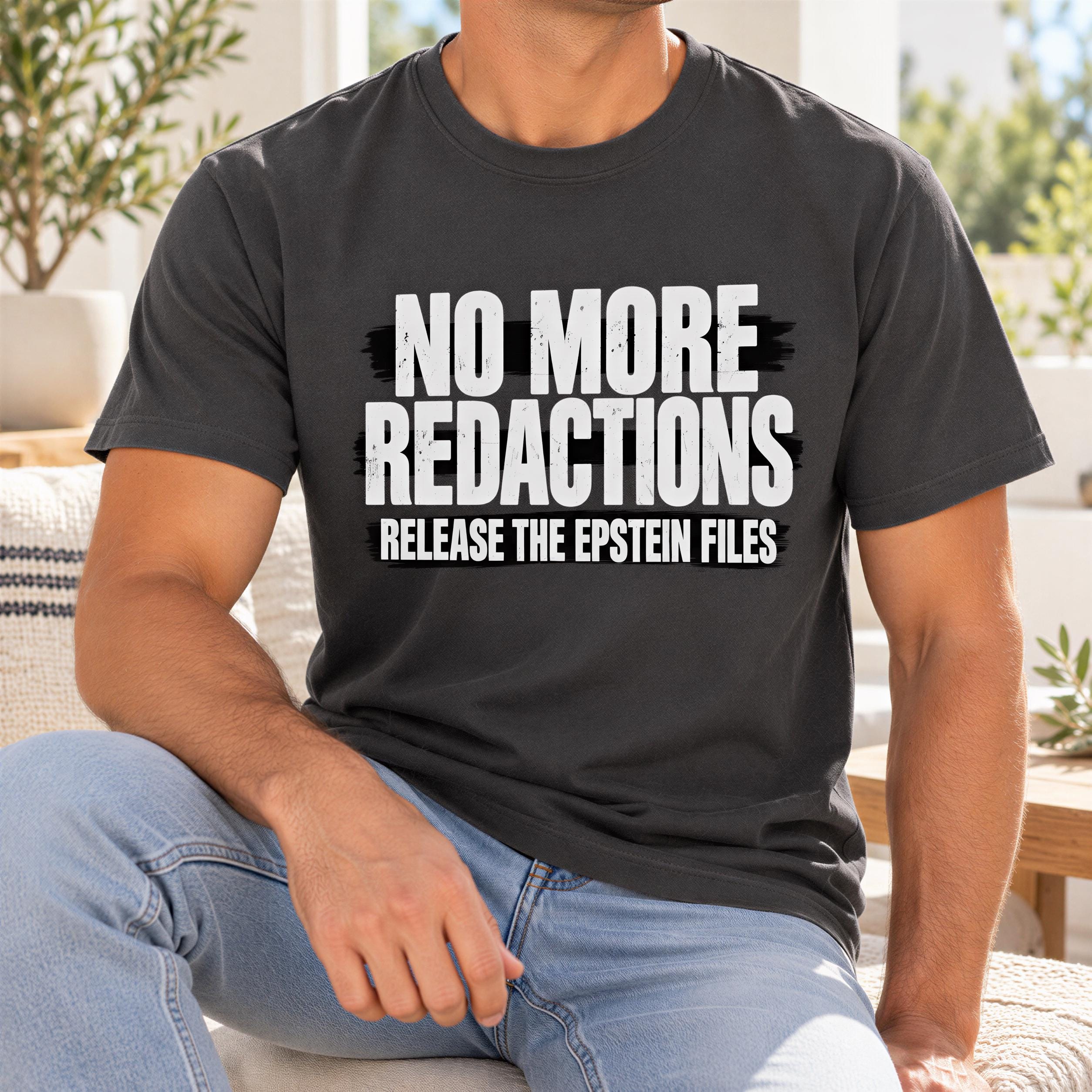 A man wearing a black t-shirt with white text that reads "NO MORE REDUCTIONS RELEASE THE EPSTEIN FILES".