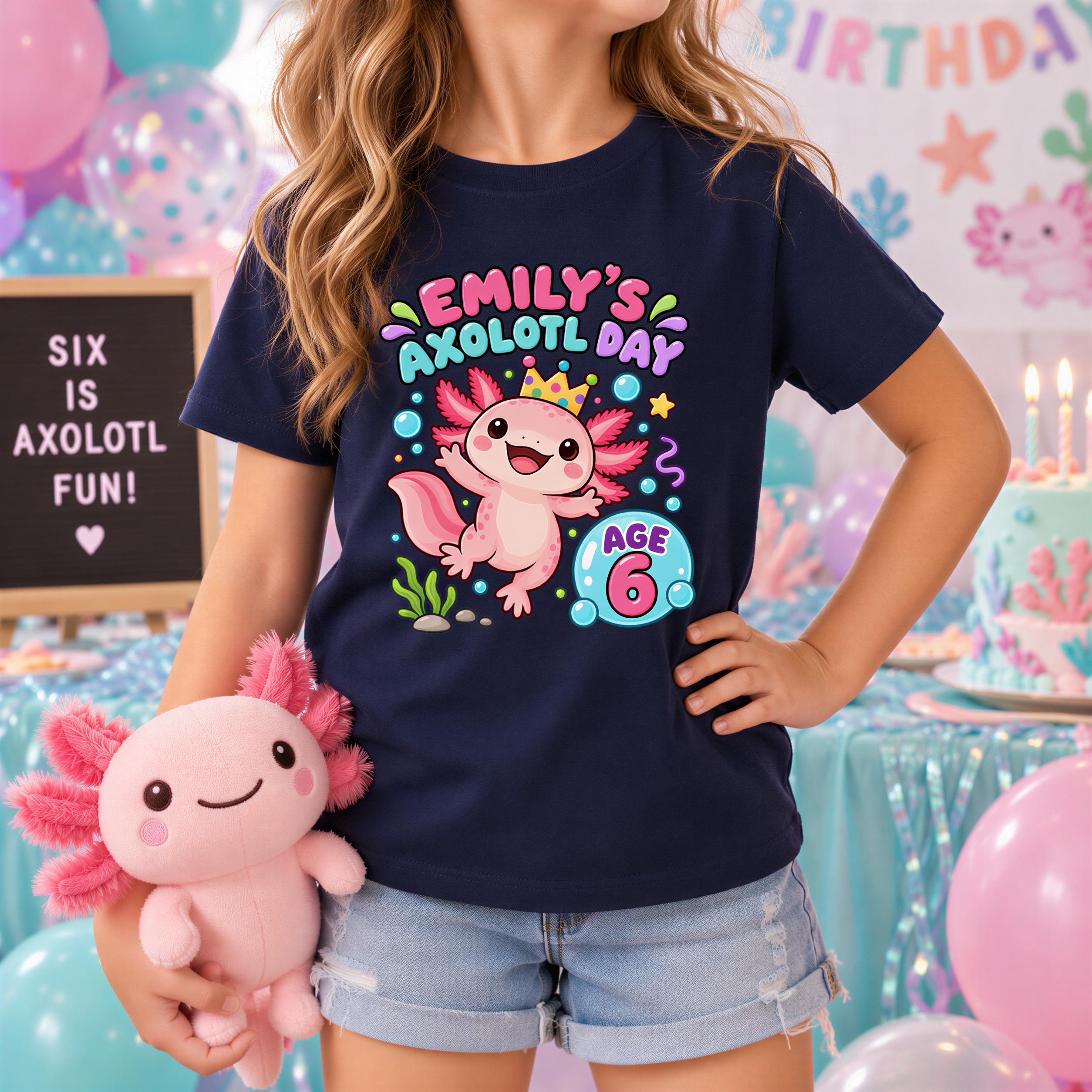A young girl wearing a blue t-shirt with a cartoon axolotl and the text "Emily's axolotl day" is holding a stuffed axolotl toy.