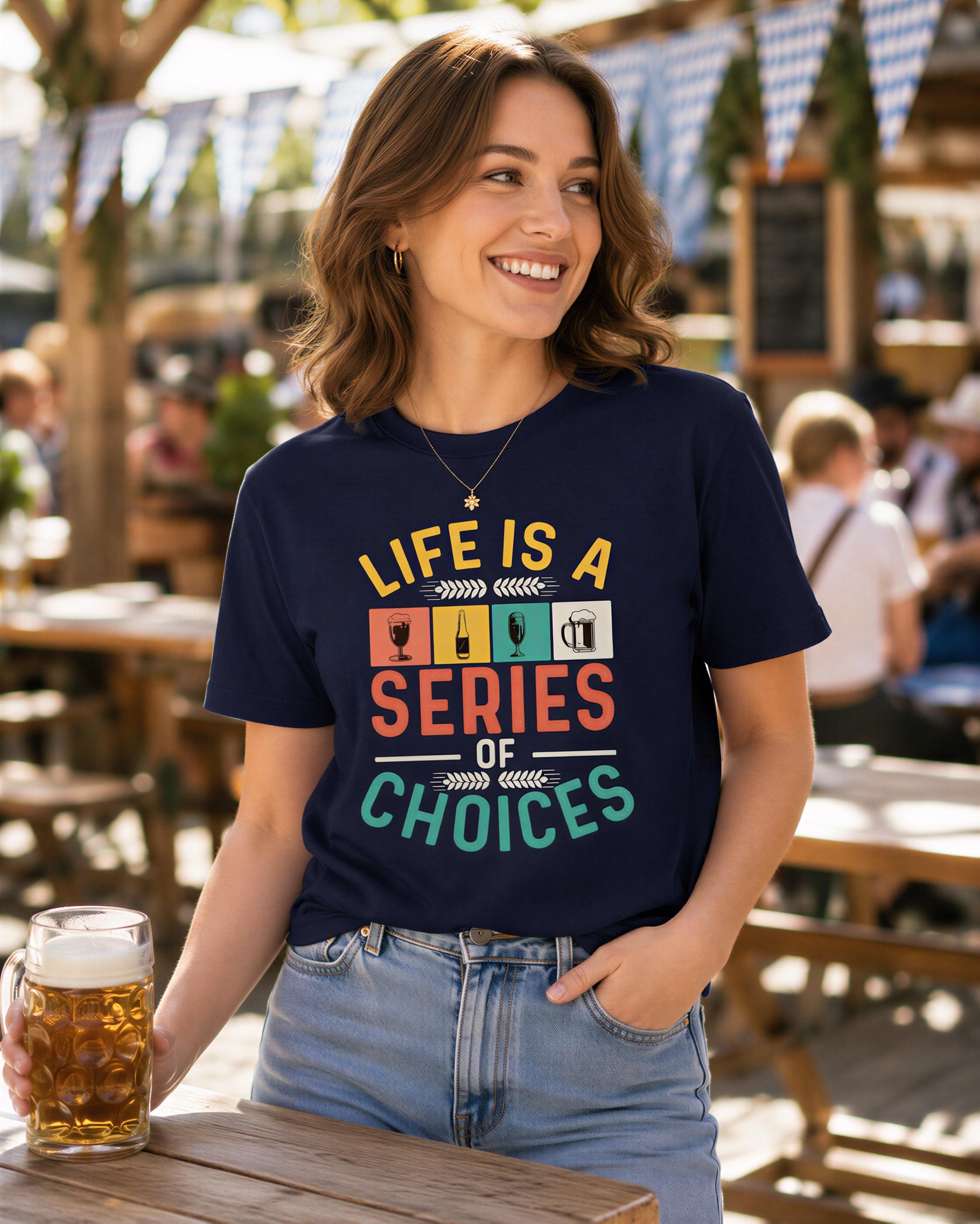 A woman wearing a navy blue t-shirt with a colorful graphic and text, smiling and holding a glass of beer at an outdoor dining area.