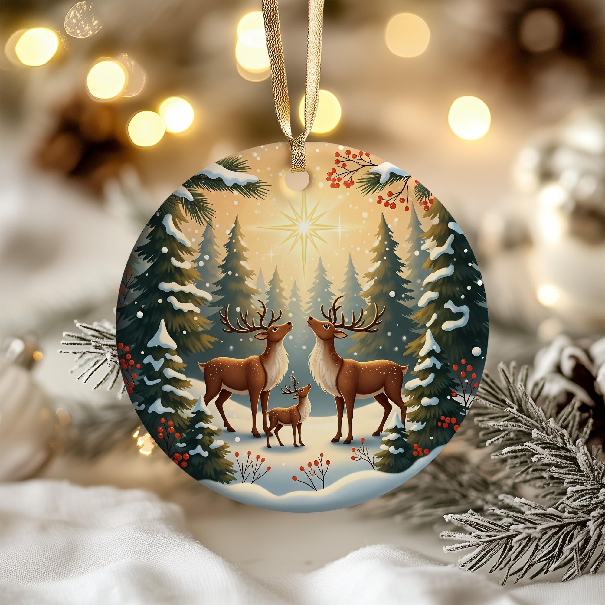 A round Christmas ornament featuring two deer standing in a snowy forest, with a star in the sky above them.