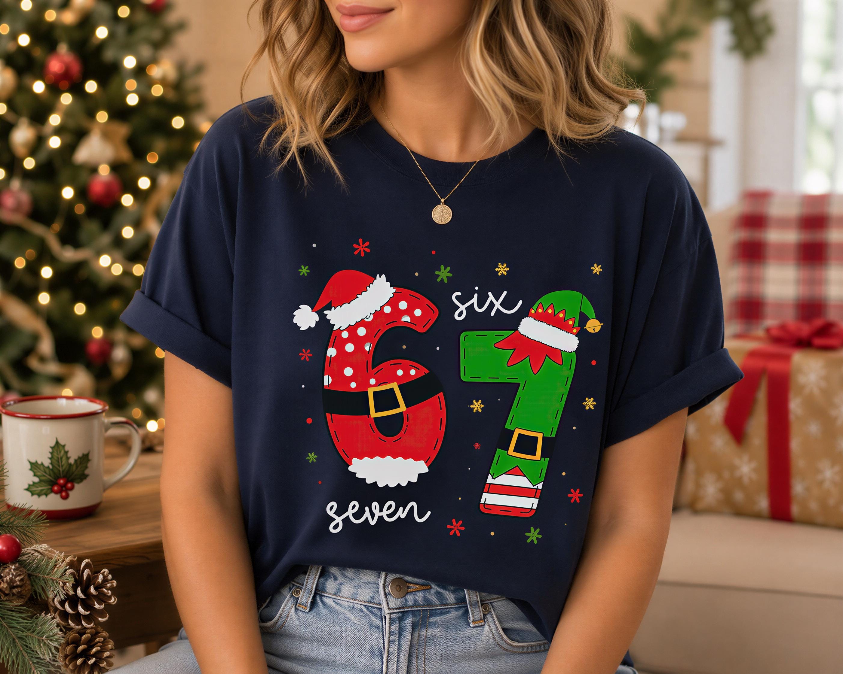 A woman wearing a navy blue t-shirt with a graphic design featuring the numbers '61' and '7' in a festive style, along with a Santa hat and other holiday-themed elements.