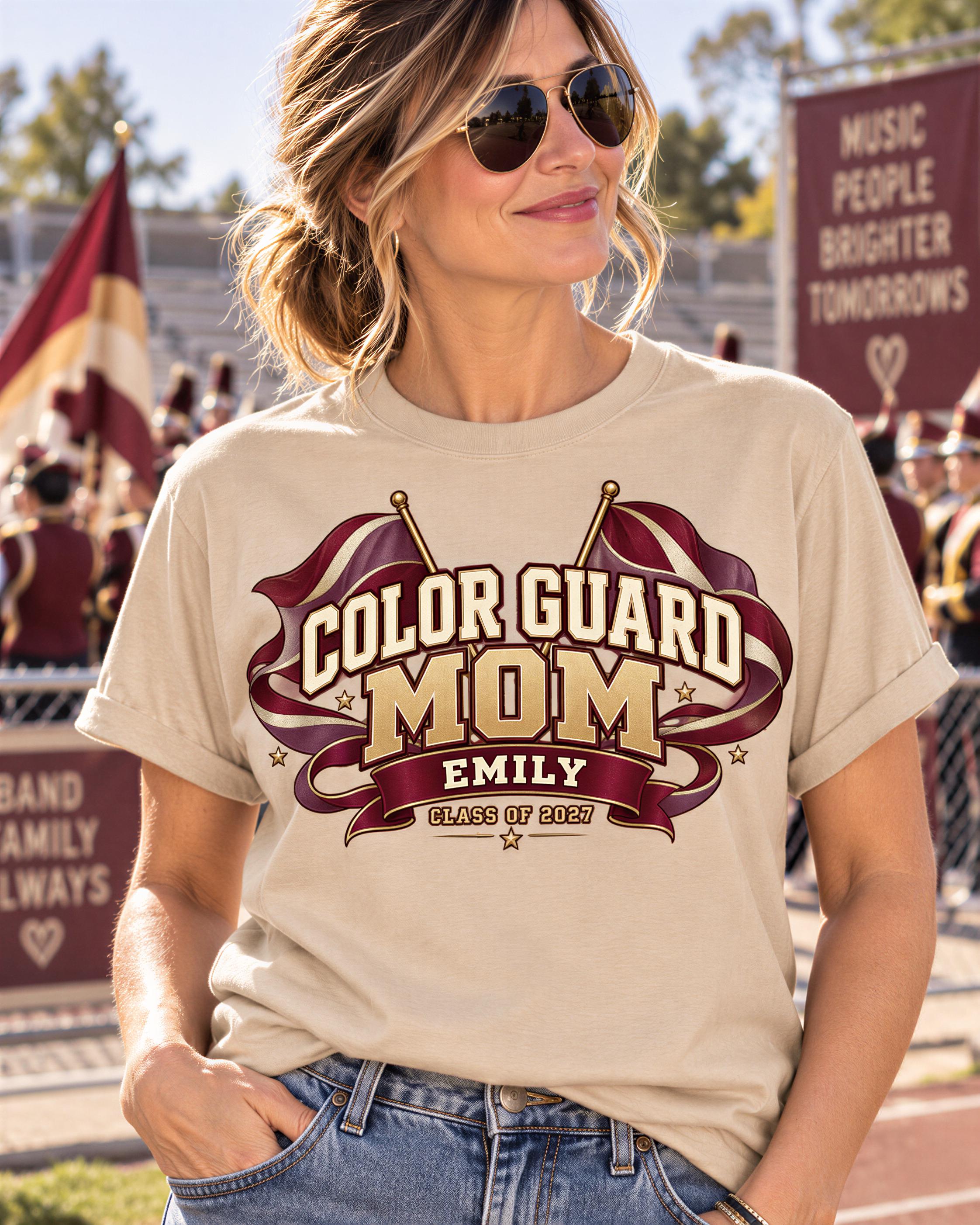 A woman wearing sunglasses and a t-shirt with a graphic design stands in front of a marching band during a graduation ceremony.