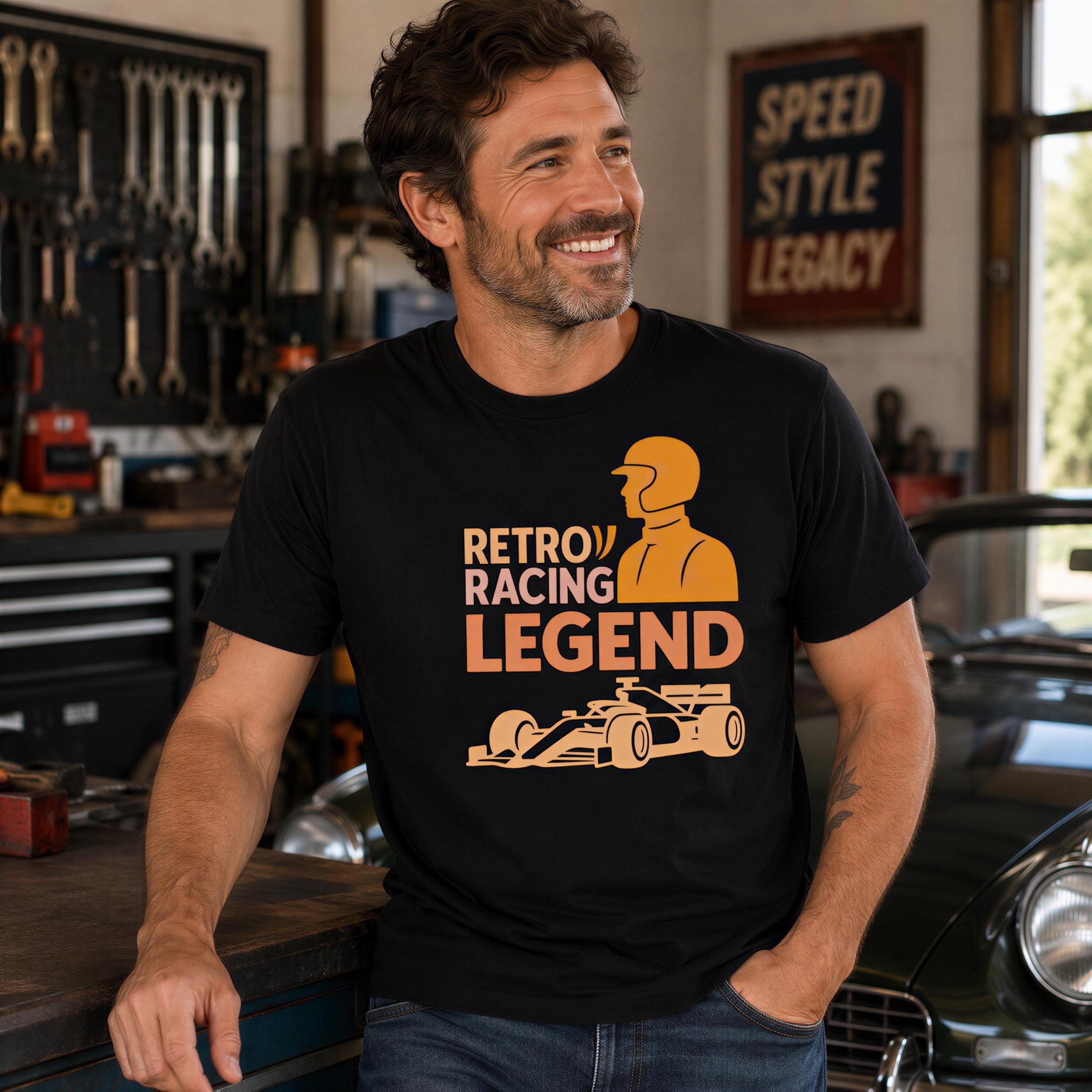 A man wearing a black t-shirt with a graphic design of a racing car and the text "Retro Racing Legend" is smiling and leaning against a workbench in a garage setting.