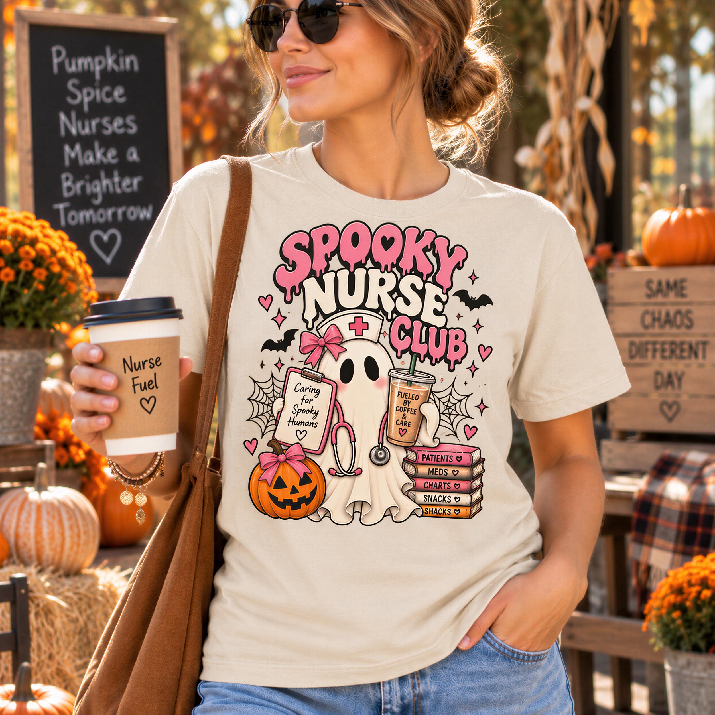 A woman wearing a white t-shirt with a graphic design of a ghost and a nurse, holding a coffee cup and standing in front of a chalkboard sign.