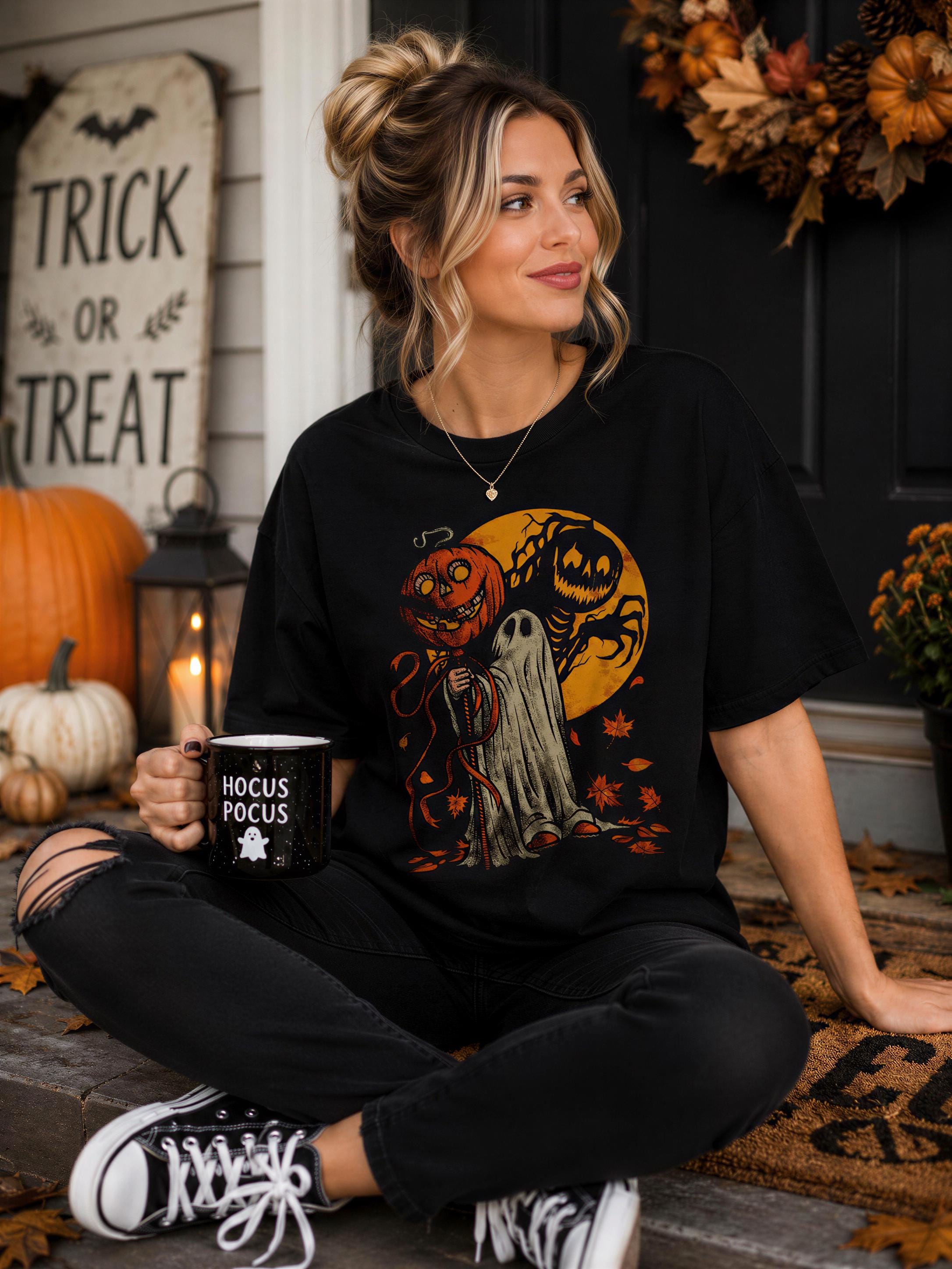 A woman sitting on a porch, wearing a black t-shirt with a Halloween-themed graphic, holding a mug with the text "Hocus Pocus".