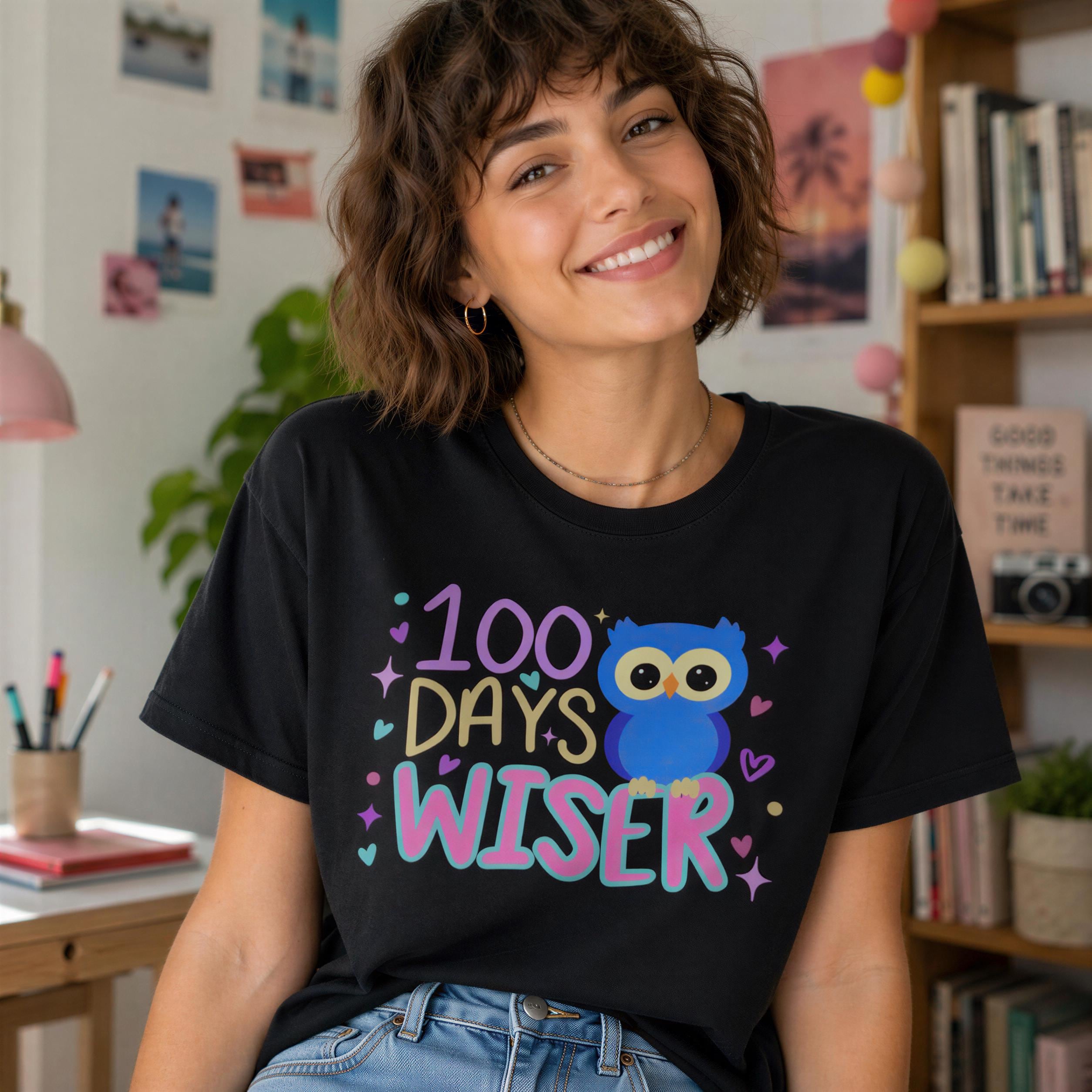 A smiling woman wearing a black t-shirt with a colorful owl graphic and text that says "100 DAYS WISER".