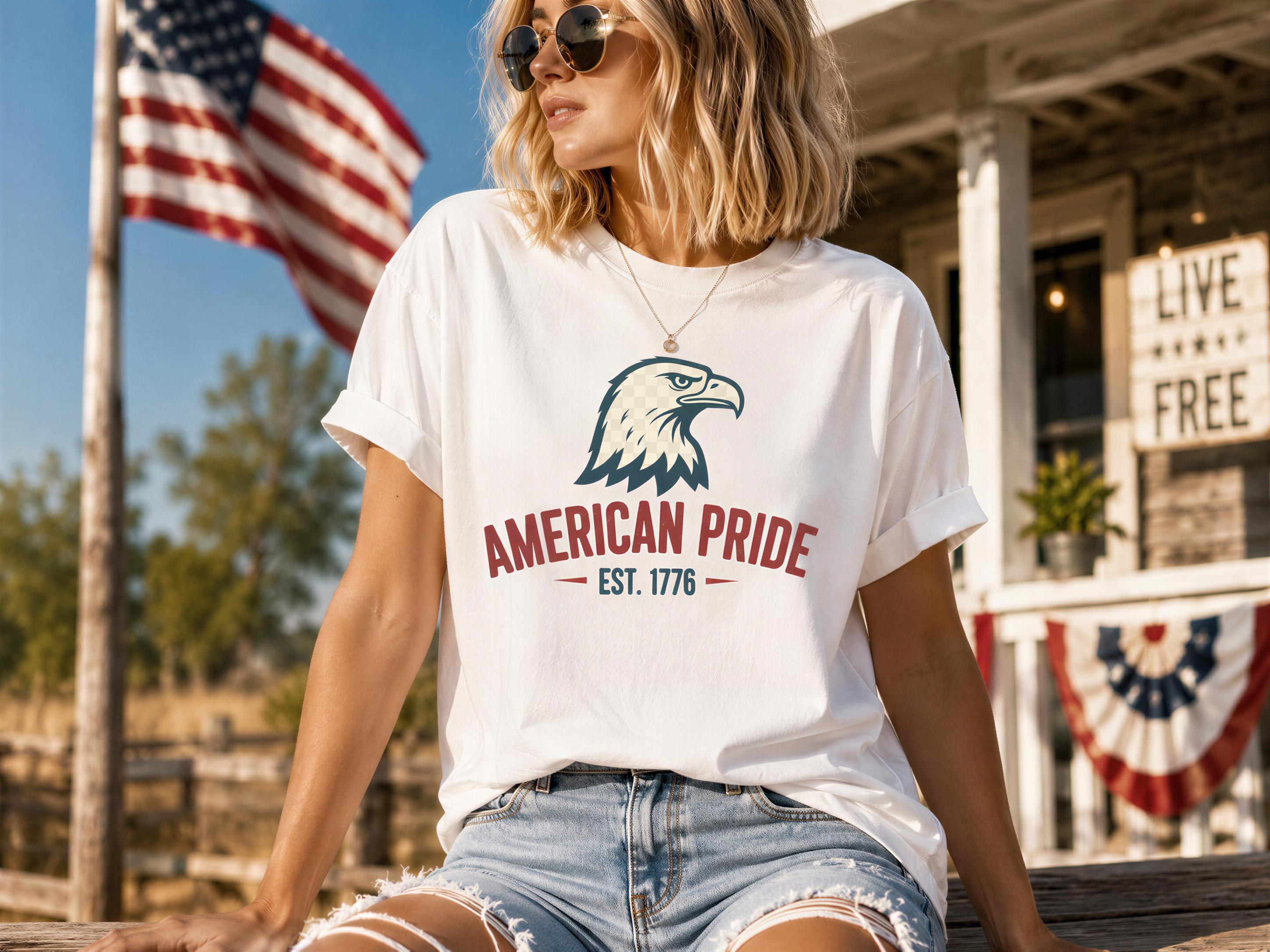 A woman wearing a white t-shirt with an eagle graphic and the text "American Pride Est. 1776" is sitting on a wooden bench in front of a building with an American flag.