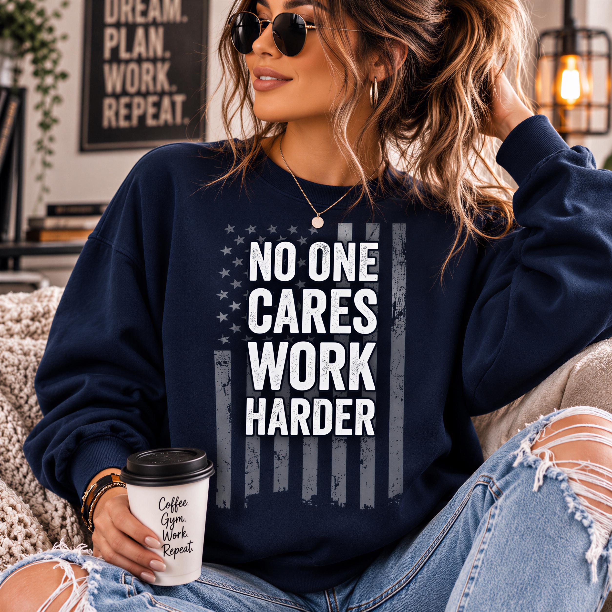 A woman wearing a navy blue sweatshirt with the text "NO ONE CARES WORK HARDER" printed on it, sitting on a couch and holding a coffee cup.