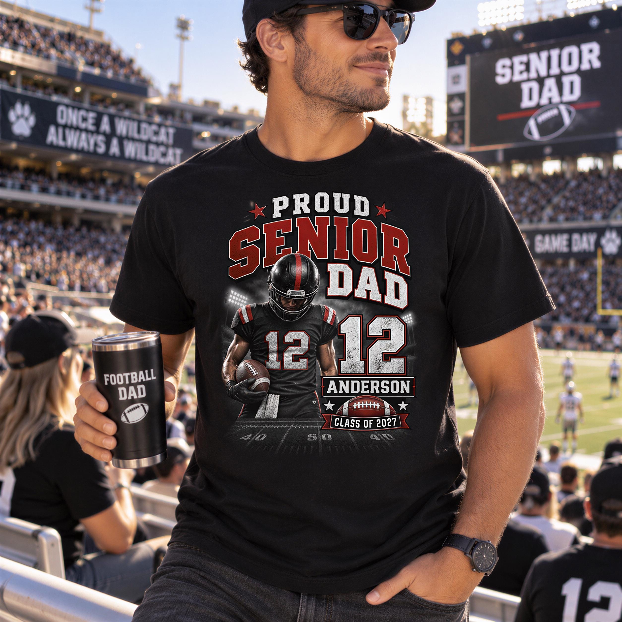 A man wearing a black t-shirt with a graphic of a football player and text that says "Proud SENIOR DAD 12" is standing in front of a crowd at a football stadium.