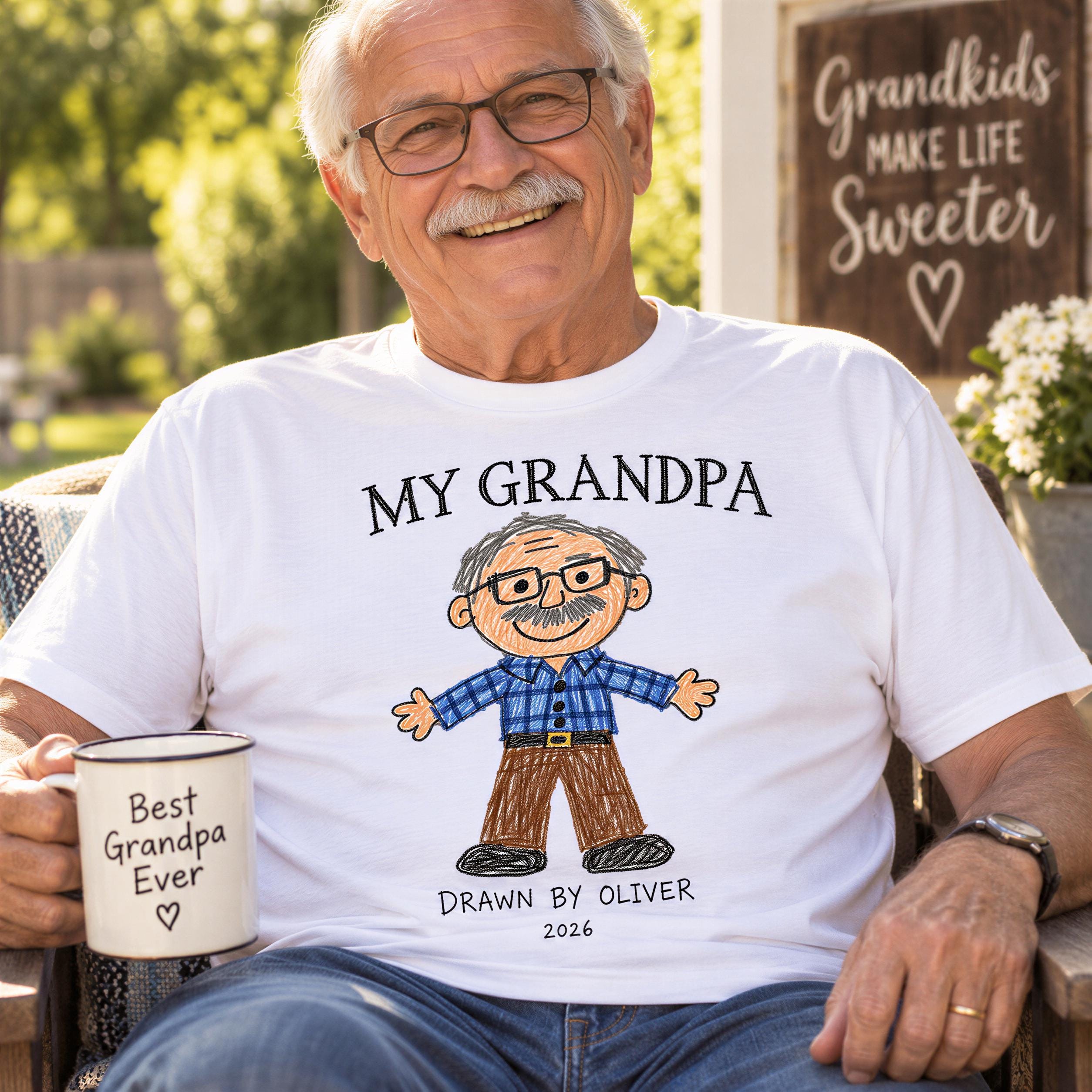 An older man wearing a white t-shirt with a cartoon drawing of a man and the text "My Grandpa" is sitting in a chair and holding a coffee mug.