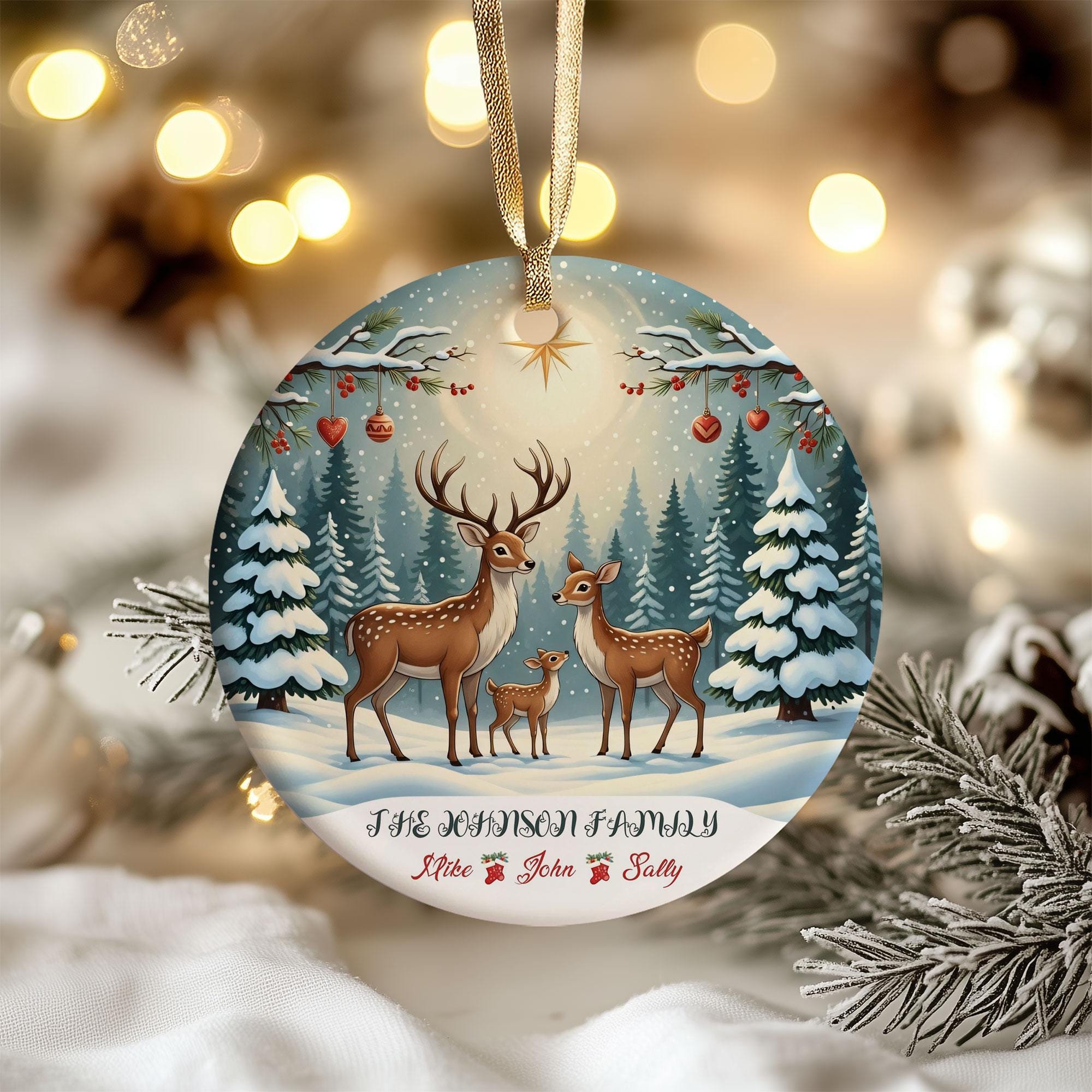 A round ornament featuring a family of deer in a snowy forest, with a star above them, and the text "The Johnson Family" and "Mike & John Sally" below.