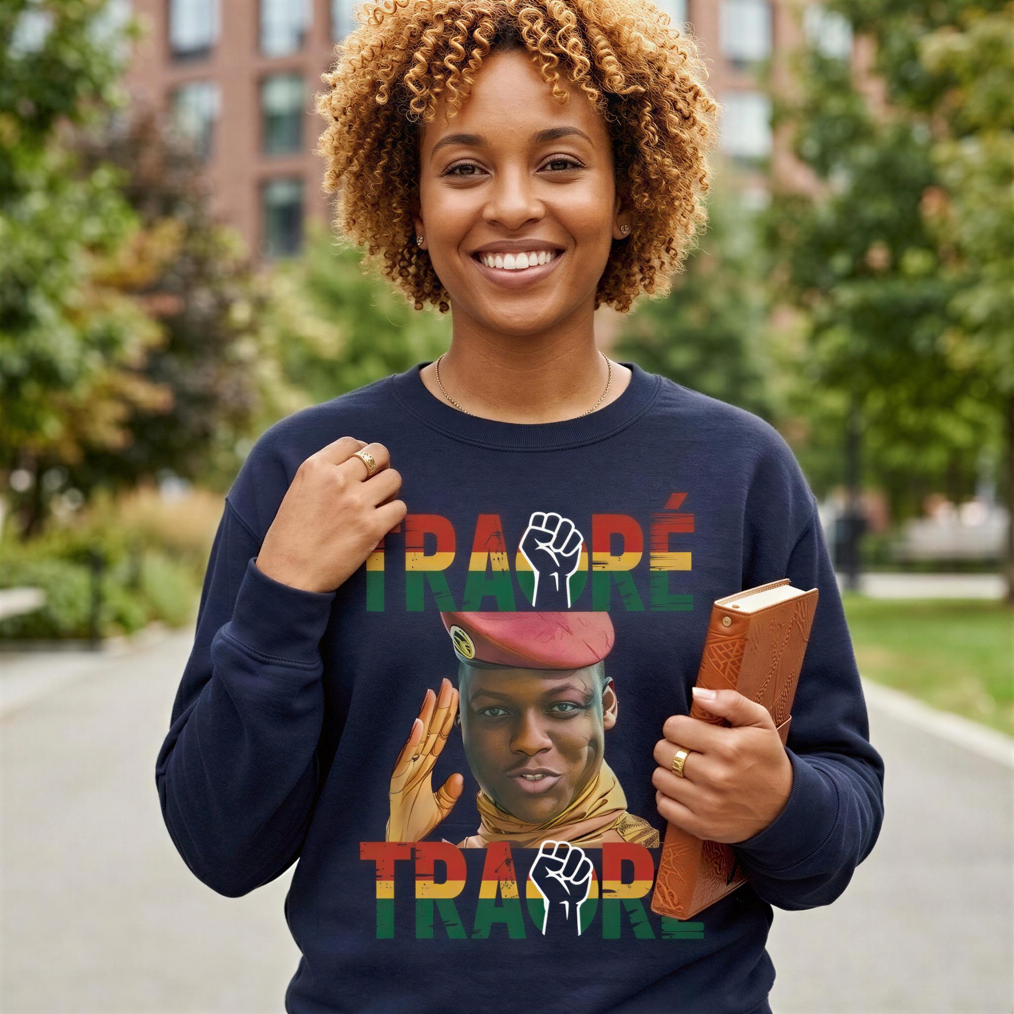 A smiling woman wearing a navy blue sweatshirt with a graphic design and text printed on it.